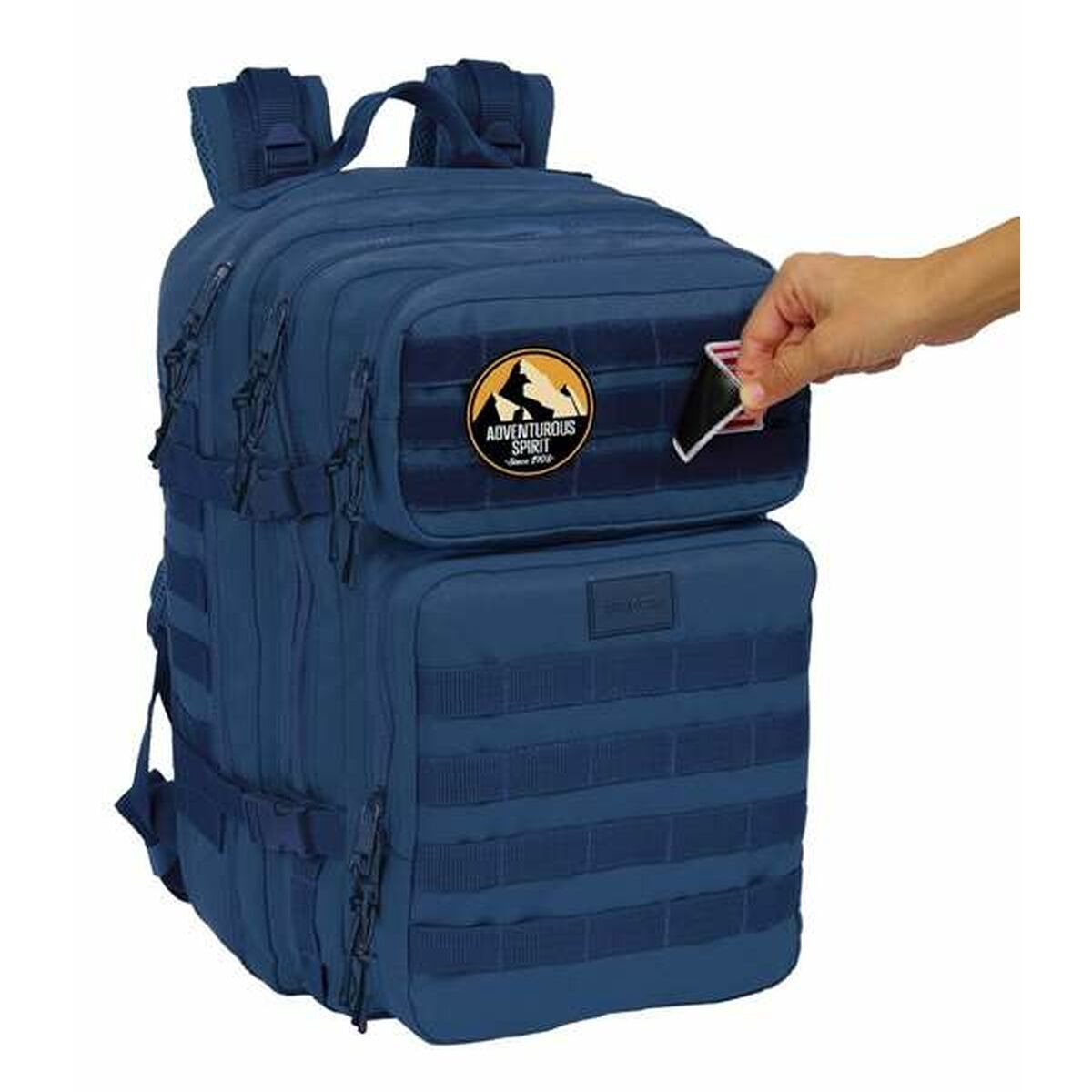 Ein blauer Rucksack mit Aufnäher und einer Hand, die eine Karte in eine Tasche steckt.