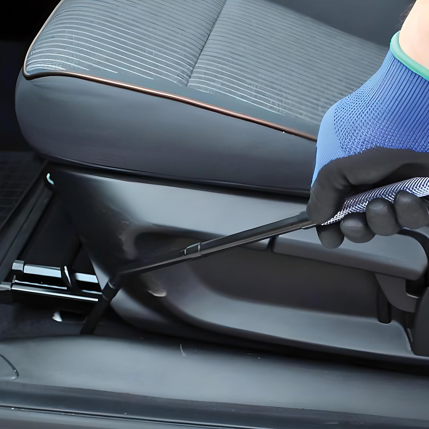 Eine Hand mit blauer Handschuh zieht einen Hebel am Autositz.