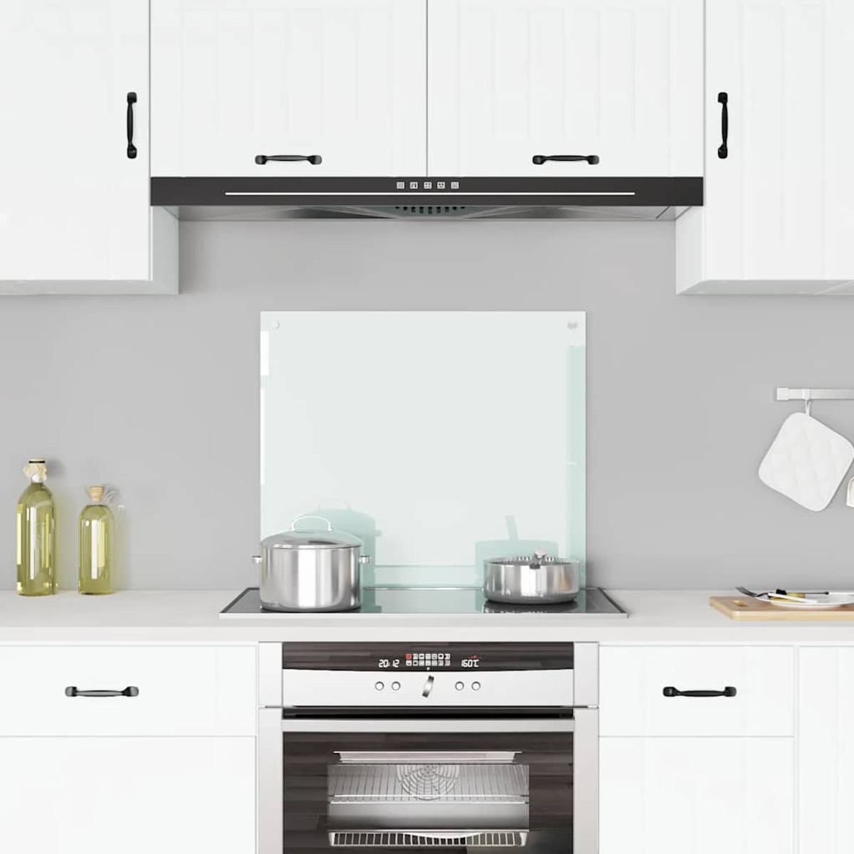 Cocina moderna con gabinetes blancos, electrodomésticos de acero inoxidable y utensilios.