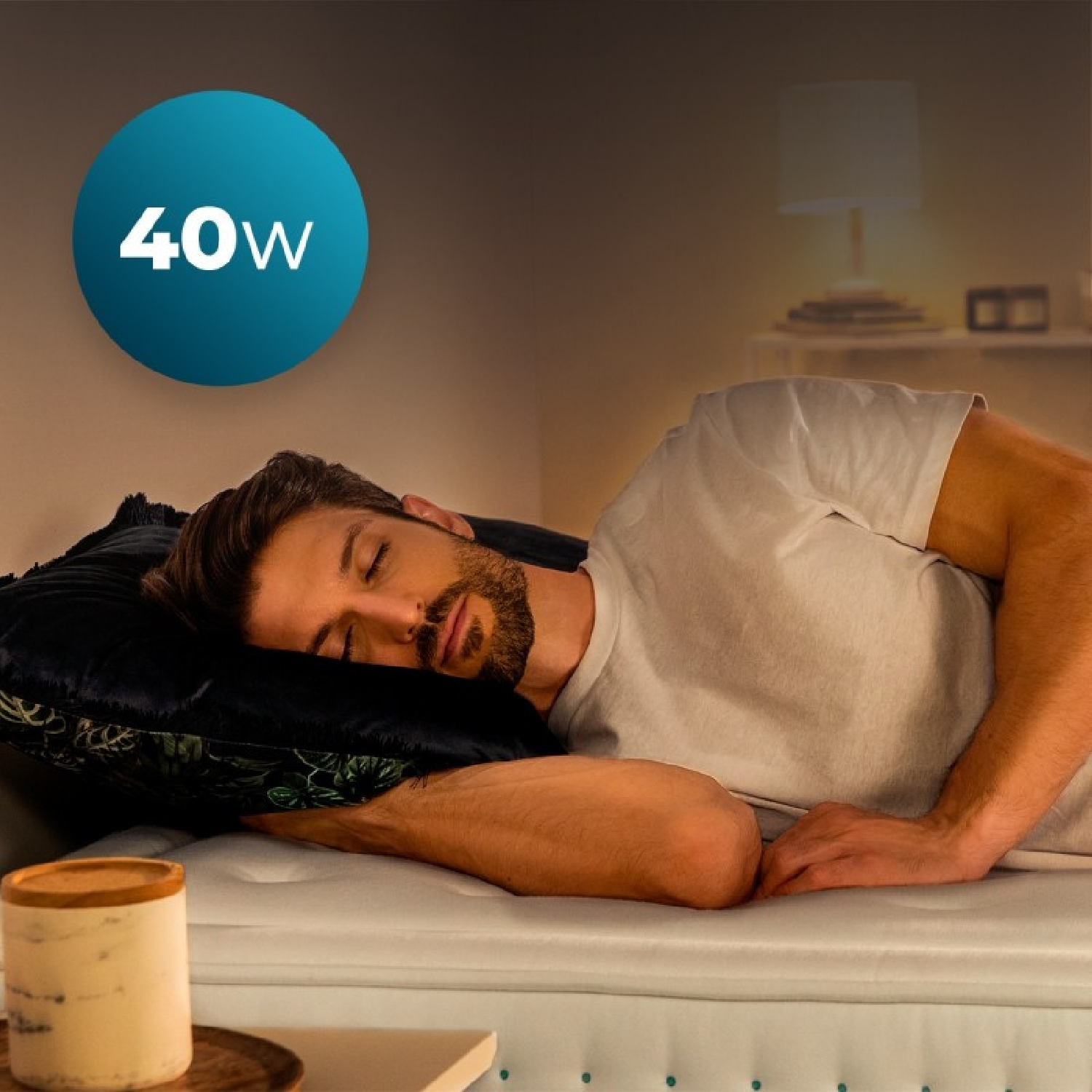 Un hombre duerme en una cama. Un círculo azul con 40W está arriba a la izquierda.