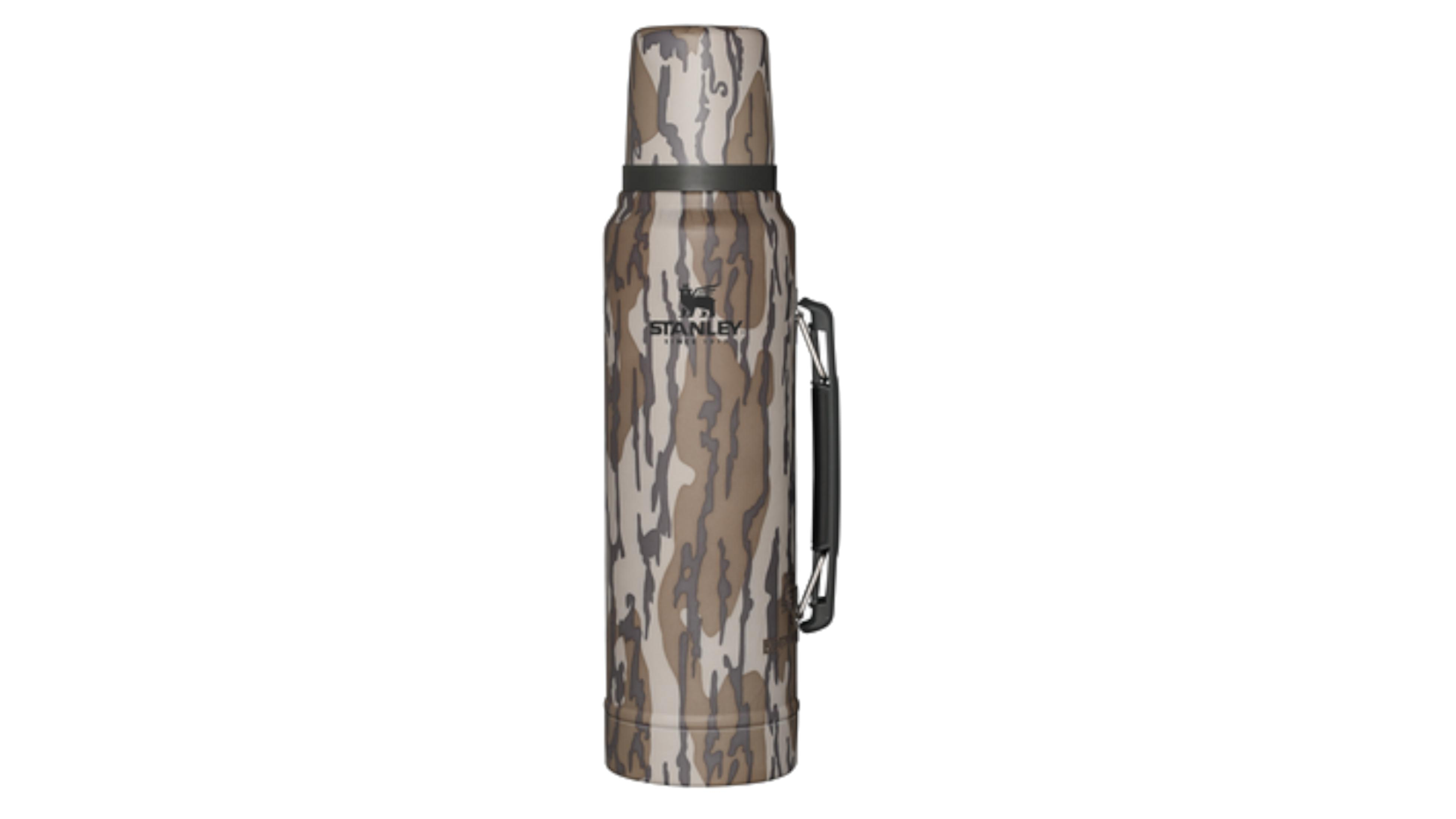 Un thermos Stanley con motivo mimetico nei toni del marrone, grigio e beige.