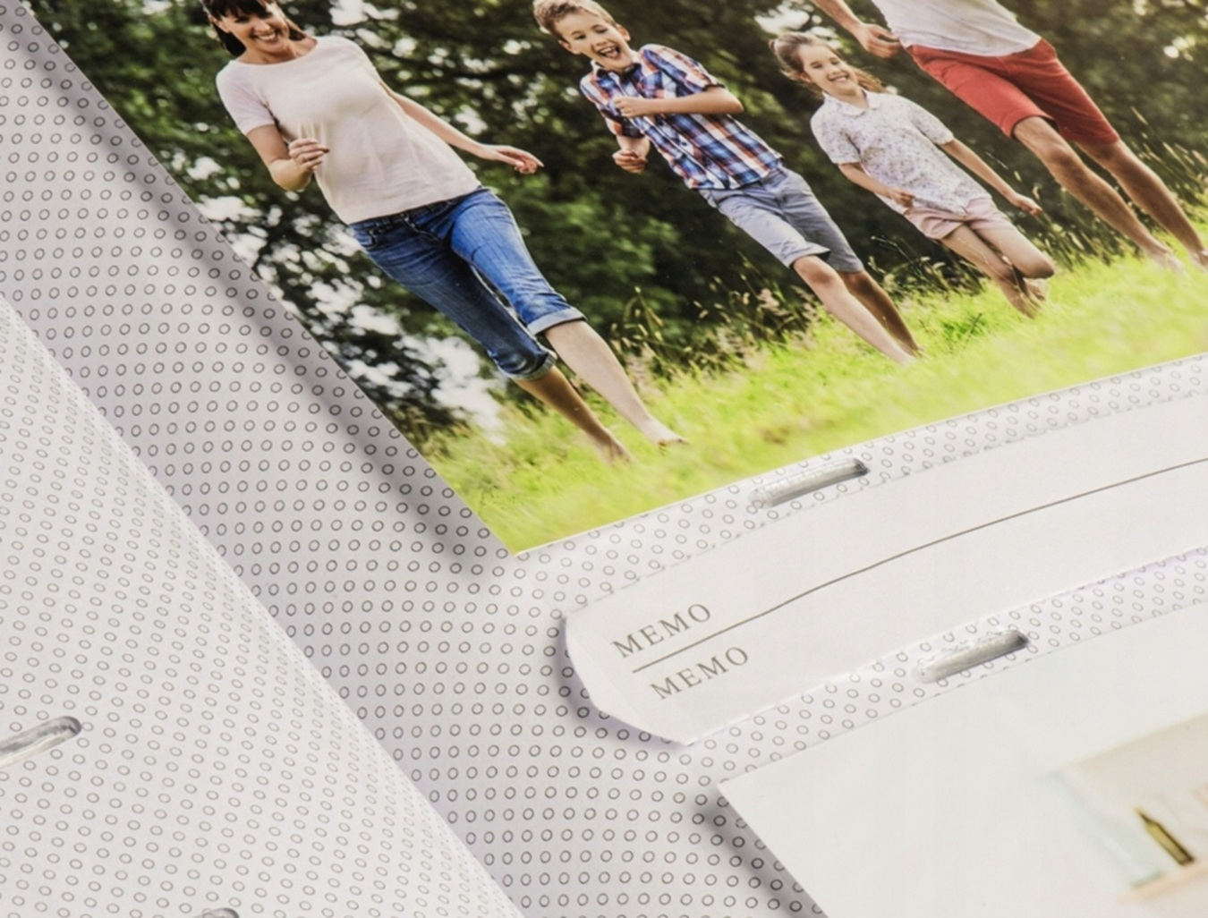 Rodzina biegnie i śmieje się na zielonym trawniku.