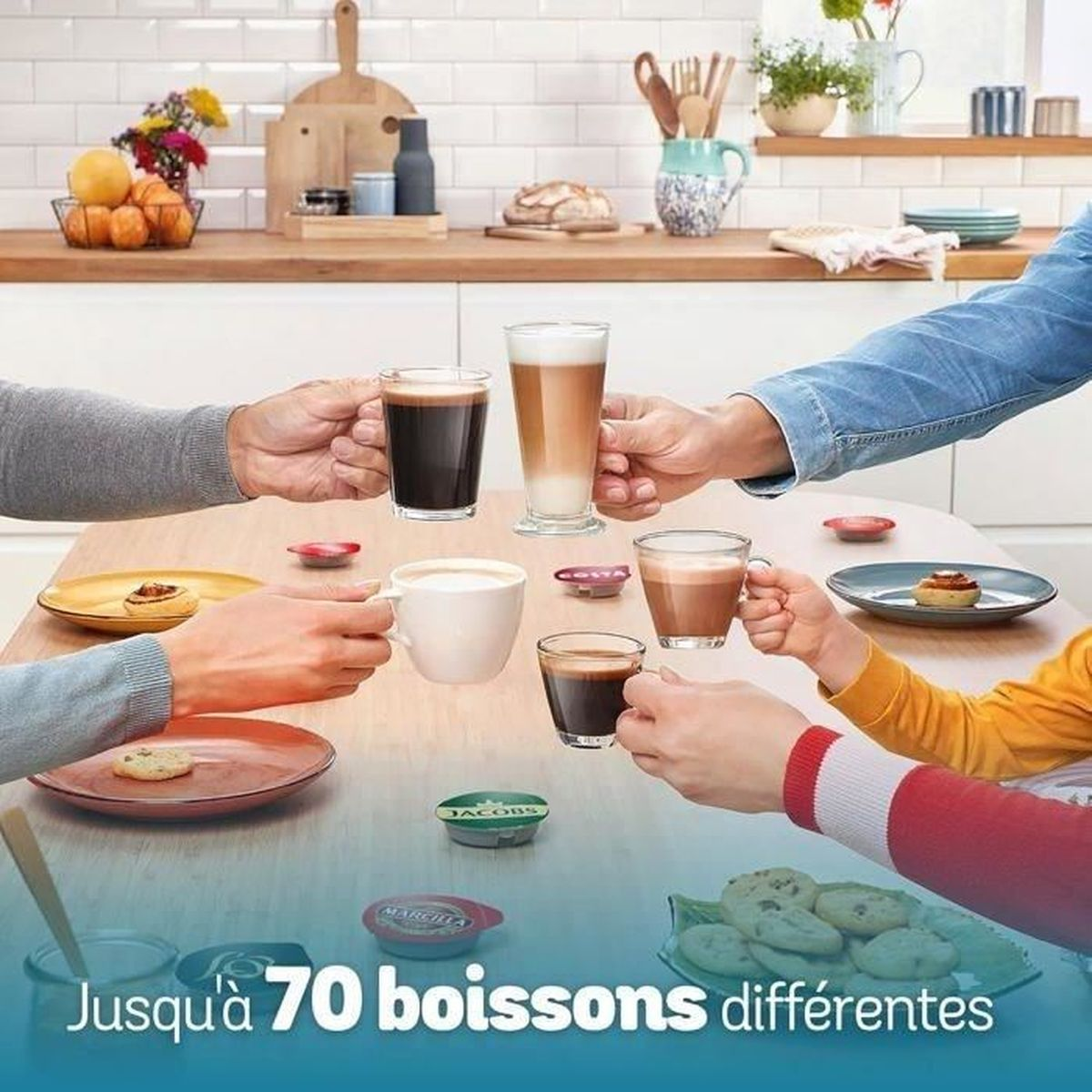 Diverse mani tengono tazze di caffè su un tavolo con biscotti e capsule.