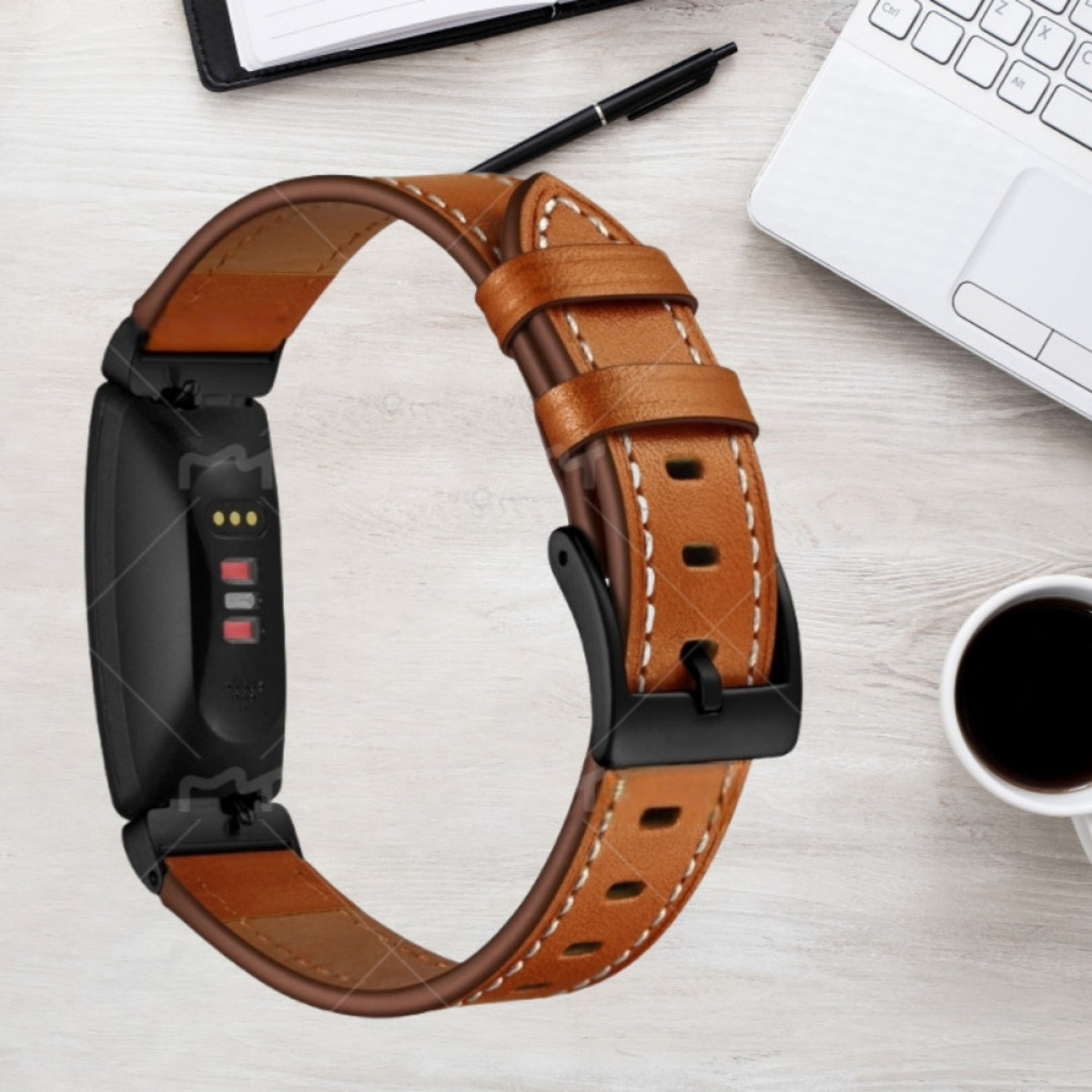 Braunes Lederarmband für ein schwarzes Fitnessarmband, auf einem Holztisch.