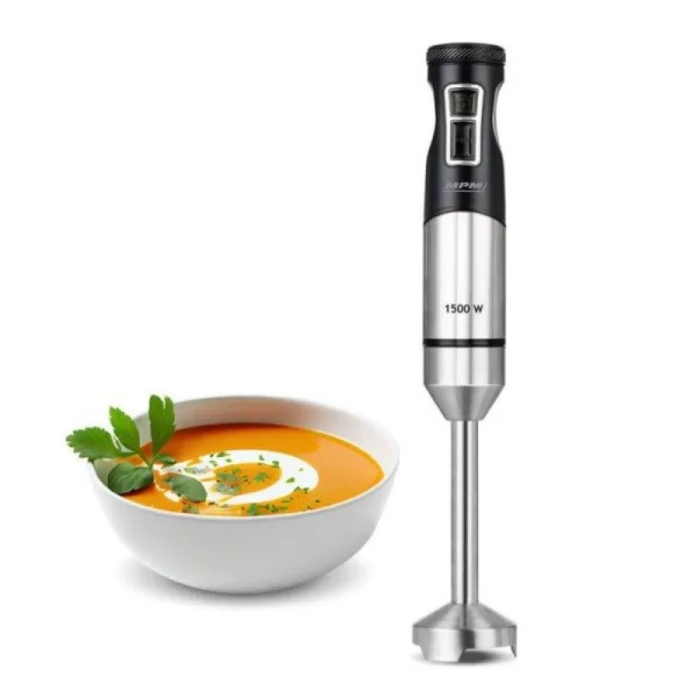 Un frullatore a immersione accanto a una ciotola di zuppa arancione guarnita con erbe.