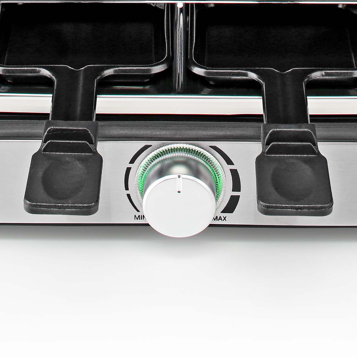 Zbliżenie srebrnego urządzenia z białym pokrętłem i czarnymi uchwytami.