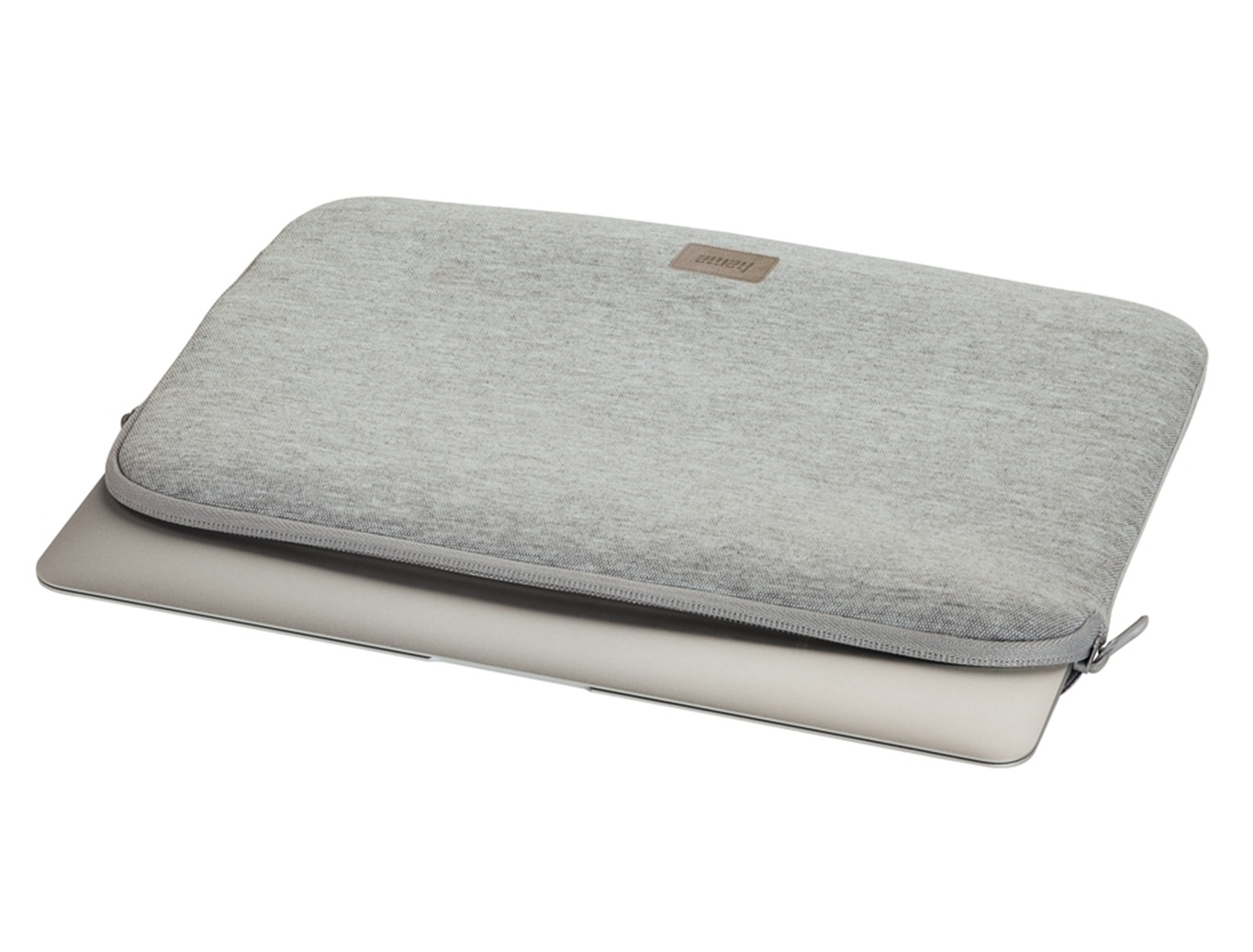 Szara torba na laptopa z zamkiem, częściowo na srebrnym laptopie.