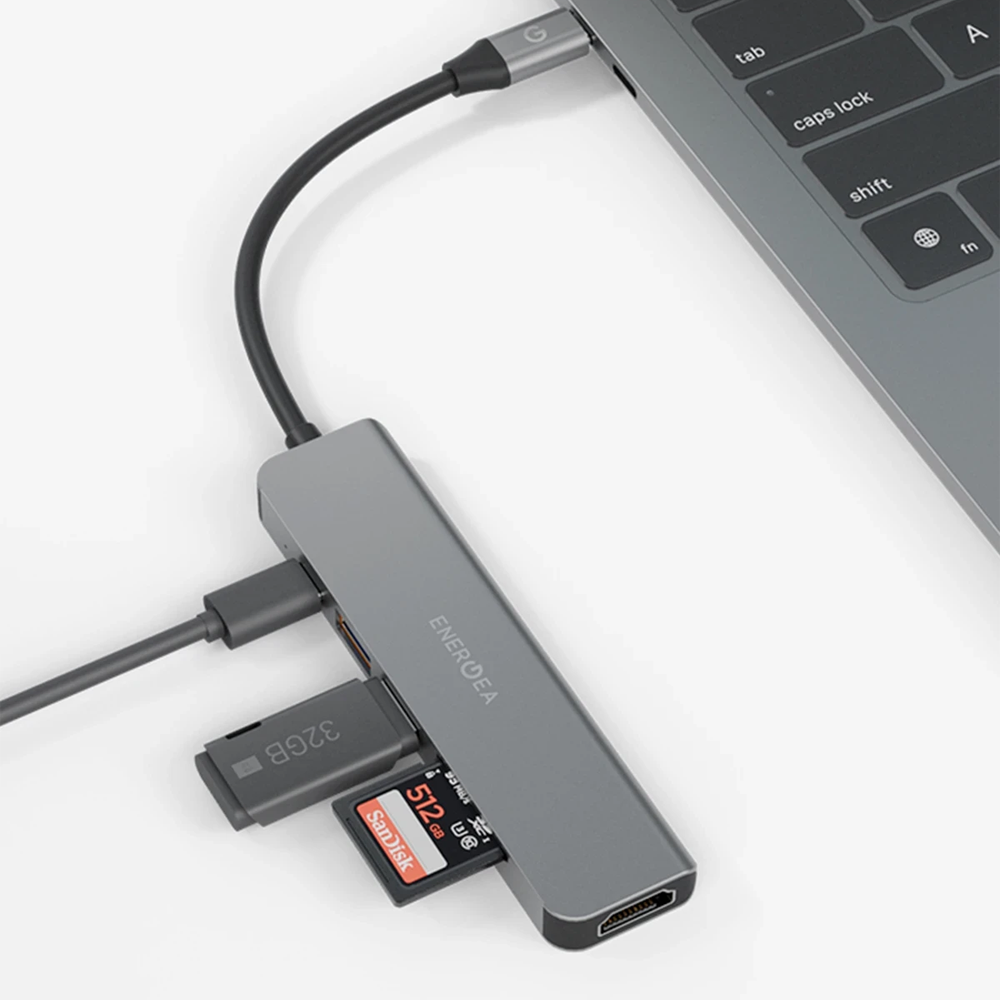 Bir dizüstü bilgisayara bağlı SD ve microSD kartlı gri USB-C hub ve HDMI bağlantı noktası.