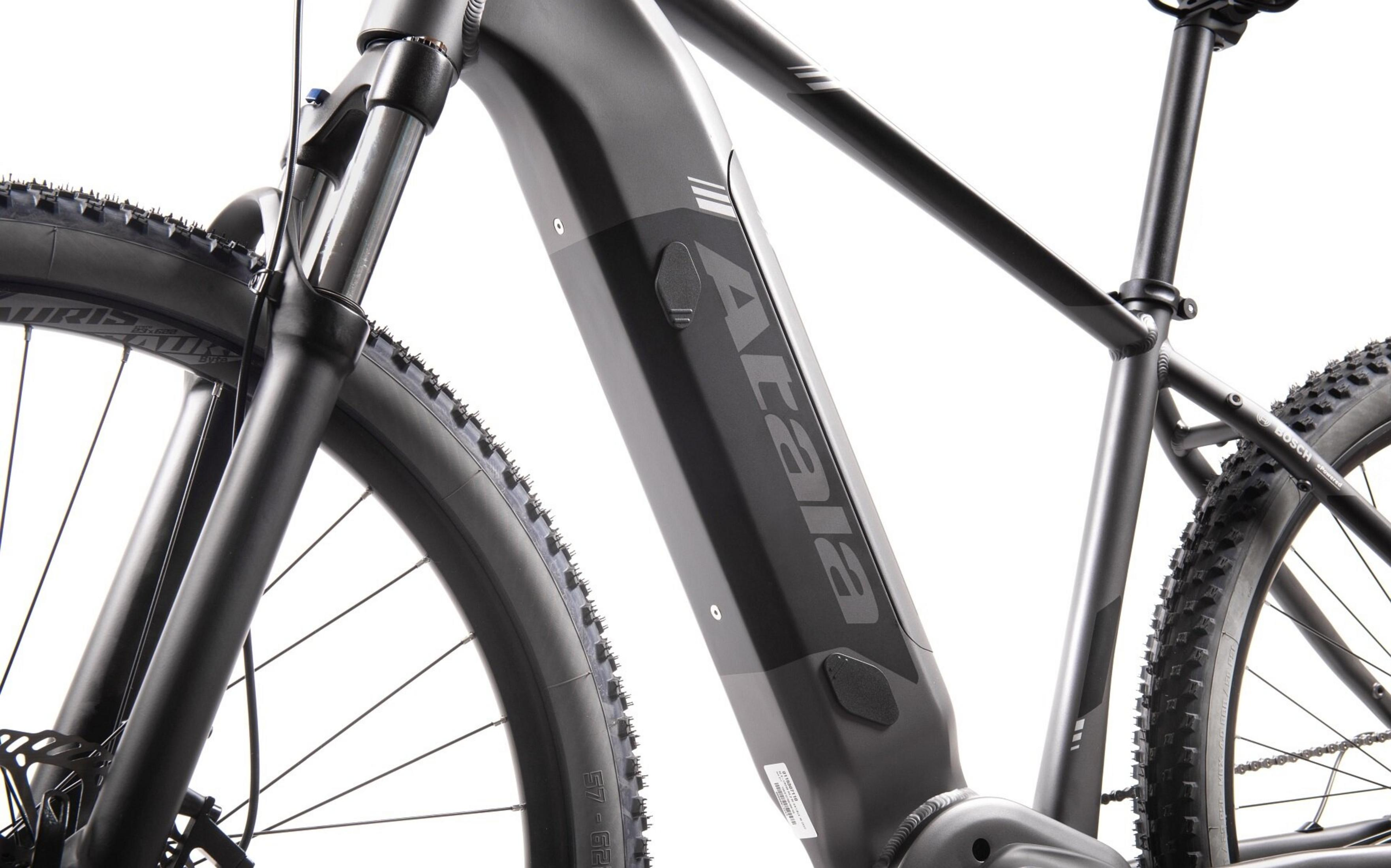 Szary rower elektryczny z czarnymi oponami i kołami. Wyraźne logo.