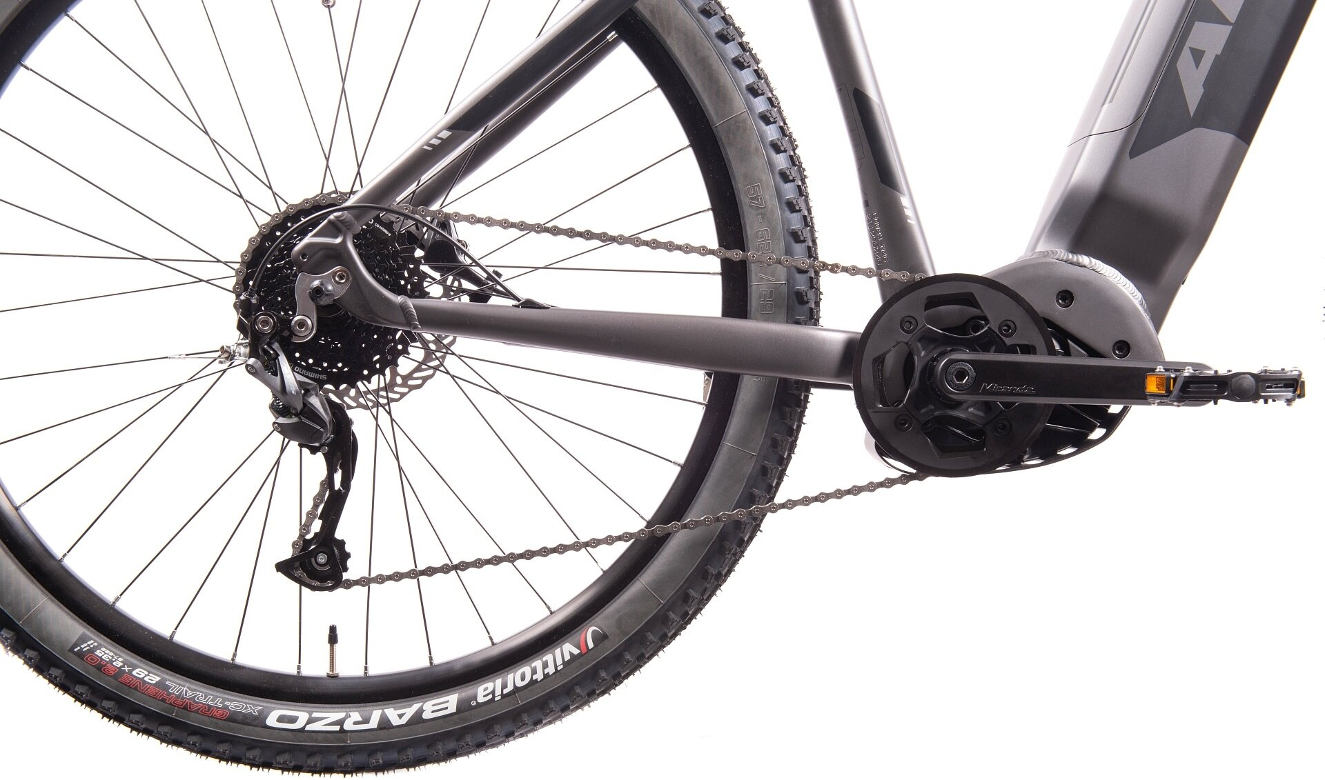 Zbliżenie na tylne koło, łańcuch i pedał ciemnoszarego roweru elektrycznego.