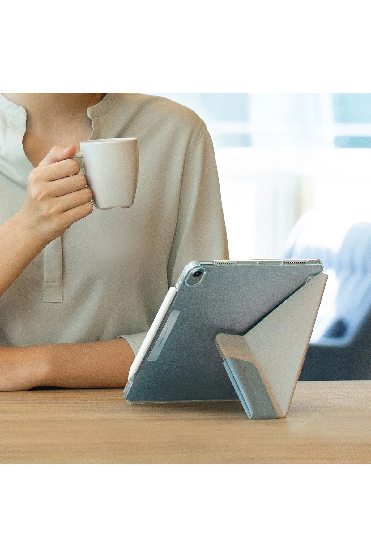 Kişi kupa tutuyor, yanında stantta tablet var.