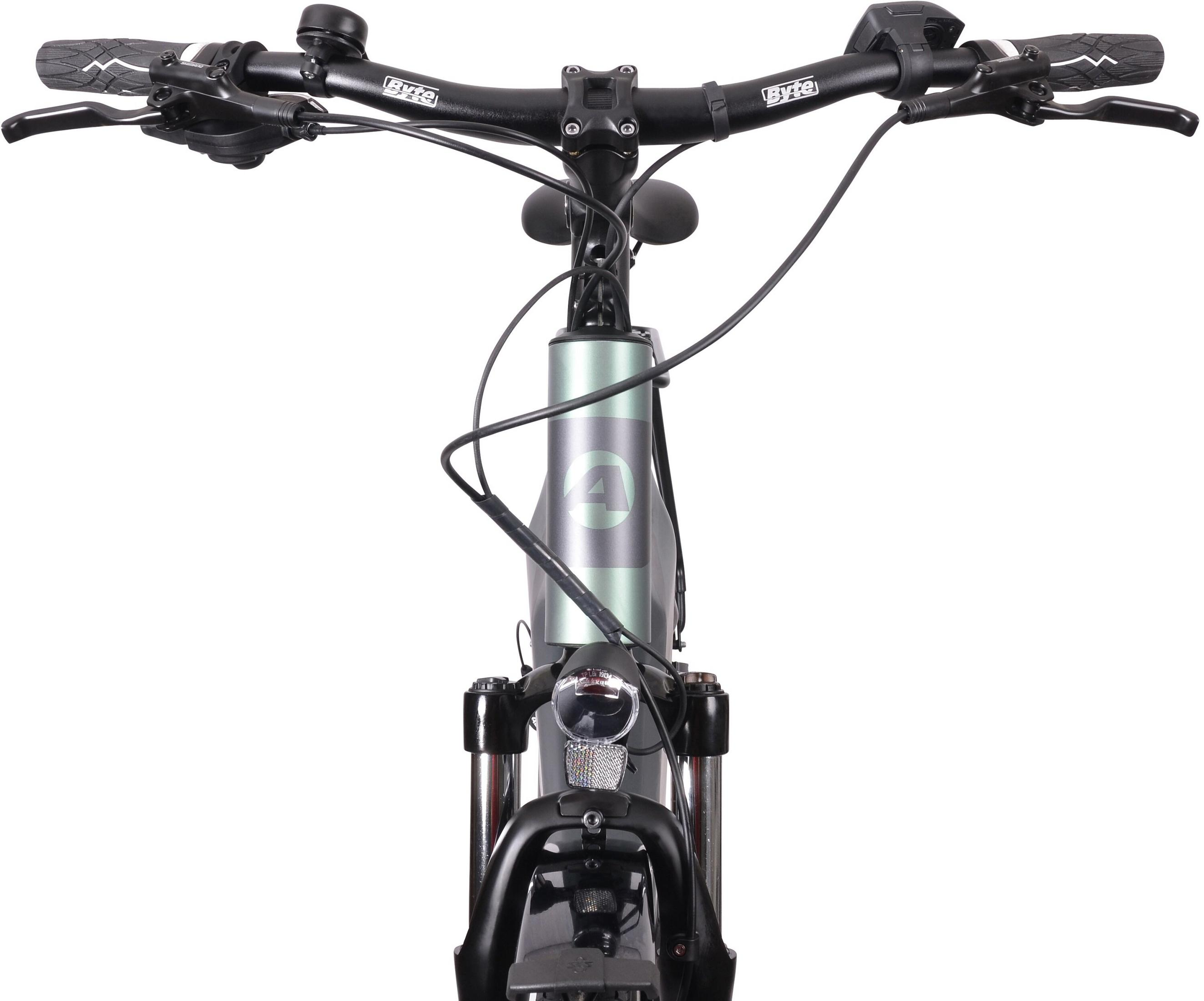 Widok z przodu miętowo-zielonego roweru elektrycznego z czarną kierownicą, dźwigniami hamulcowymi i reflektorem. Rama ma szare logo '4'.