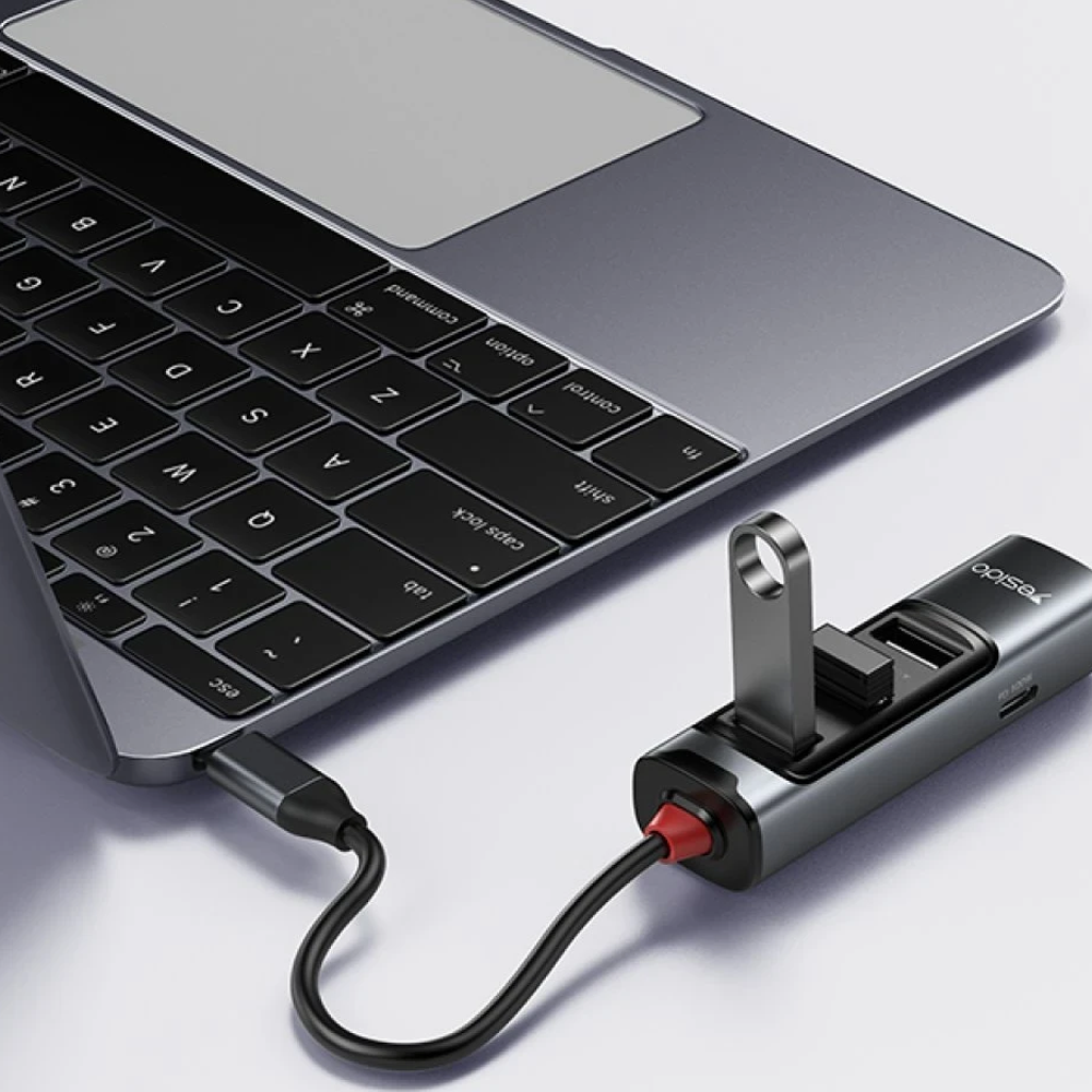 Portlu gri bir USB hub dizüstü bilgisayara bağlı.