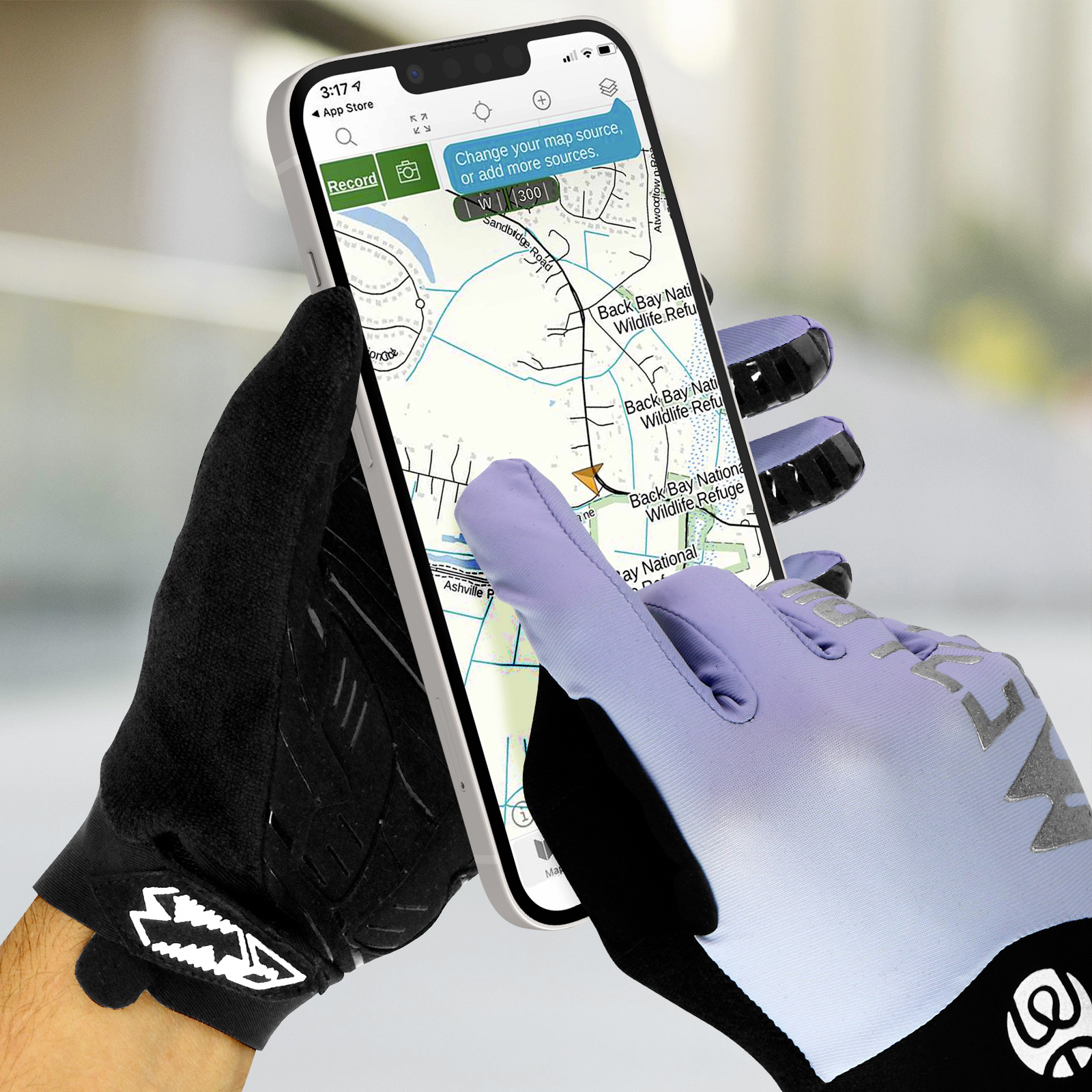 Una persona con guanti neri e viola tiene uno smartphone bianco che mostra un'applicazione di mappe.