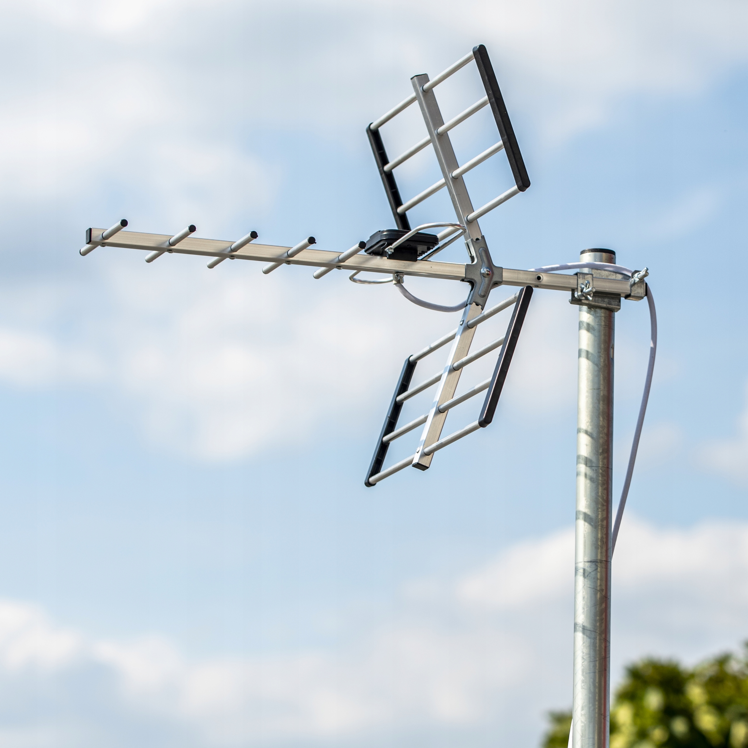 Antena z elementami i słupem na tle błękitnego nieba.