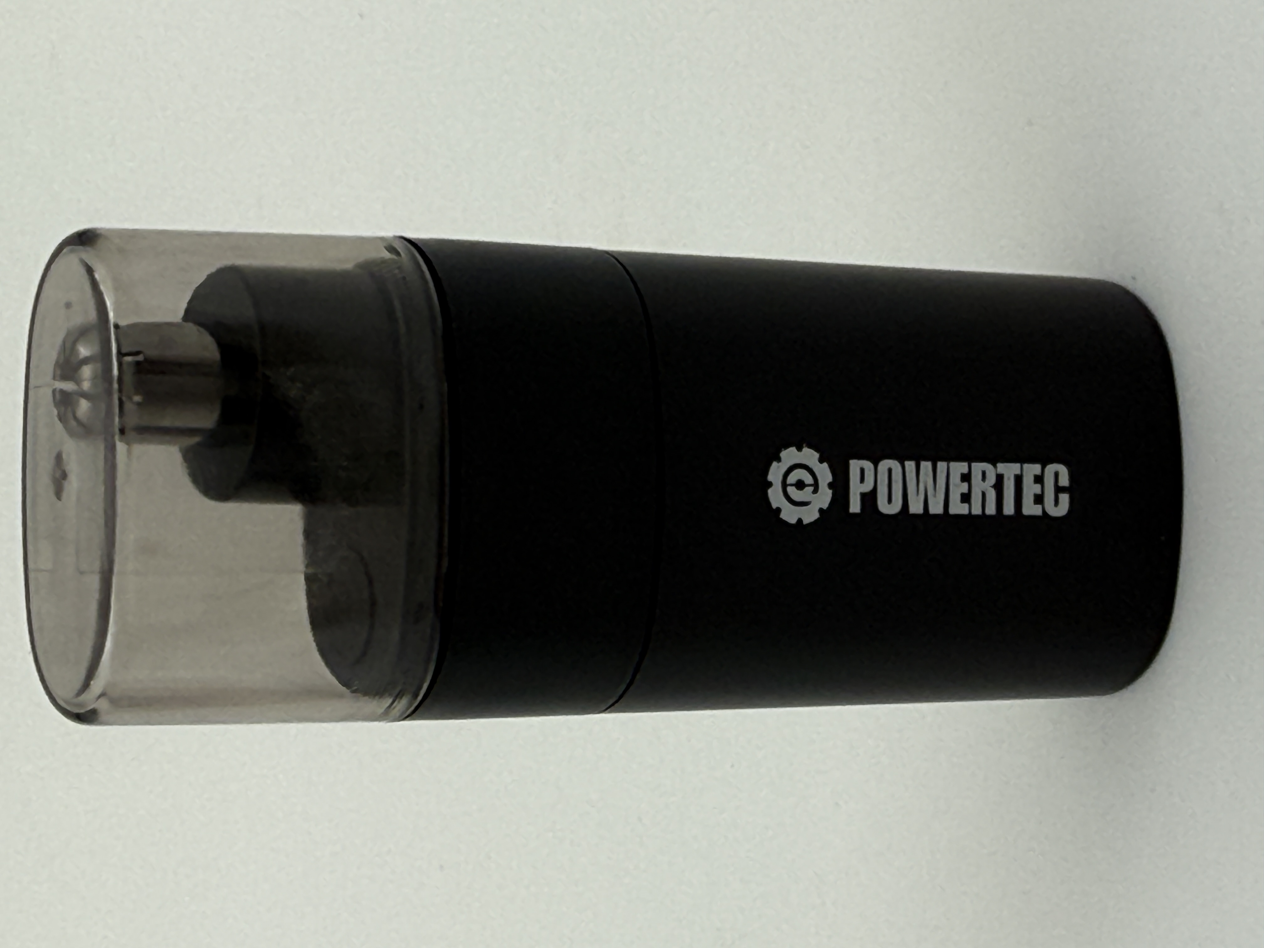 Bir ucunda şeffaf plastik kapak ve yan tarafında beyaz 'POWERTEC' logosu bulunan siyah silindirik bir kalemtıraş.