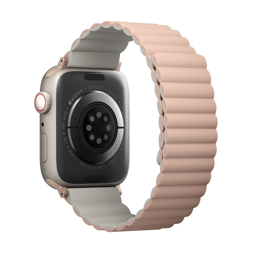 Şeftali renkli nervürlü kayışa sahip altın rengi bir Apple Watch Series 7 arkadan görülüyor, sensörlerini gösteriyor.