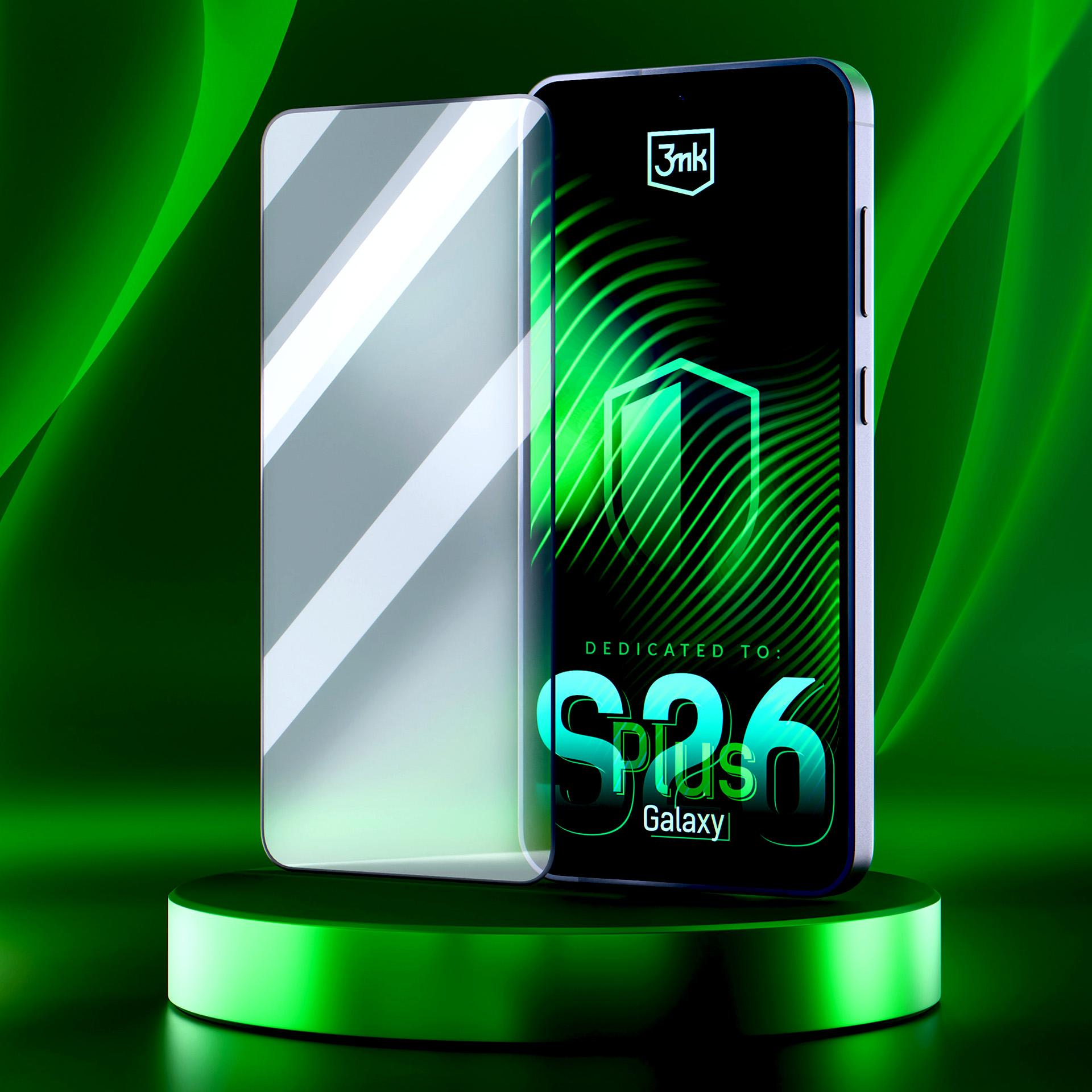 Smartfon z ochraniaczem ekranu na zielonym cokole. Na ekranie widnieje napis „S26 Plus Galaxy”.