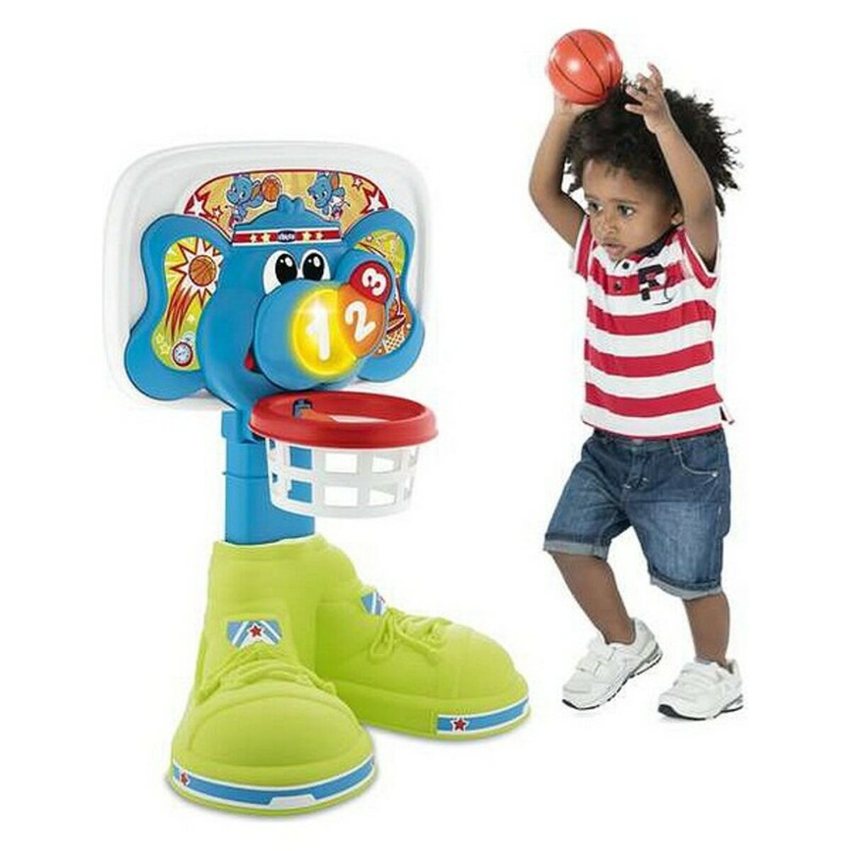 Ein Junge wirft einen Ball in einen Spielzeug-Basketballkorb mit Elefantenmotiv.