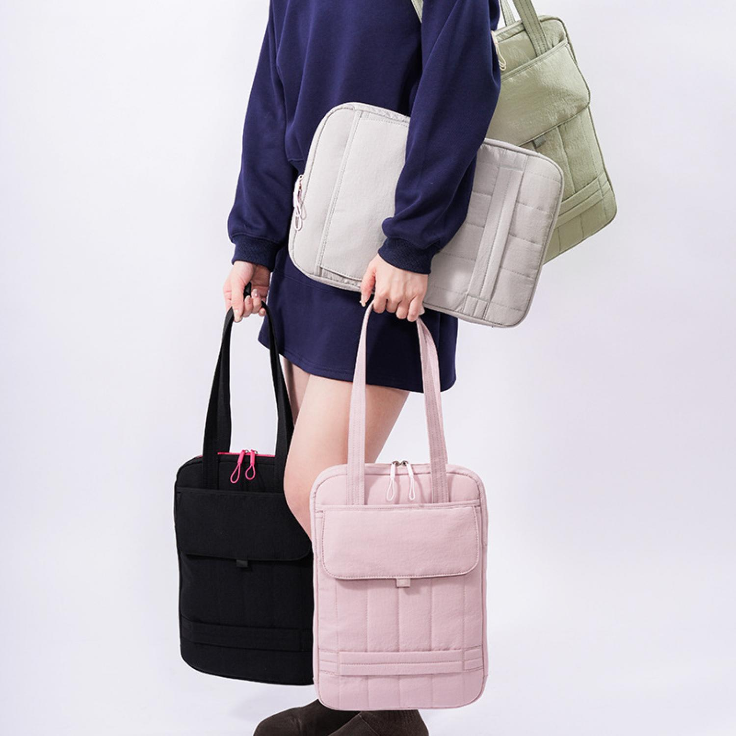 Person hält drei gesteppte Taschen in Grau, Rosa und Grün.