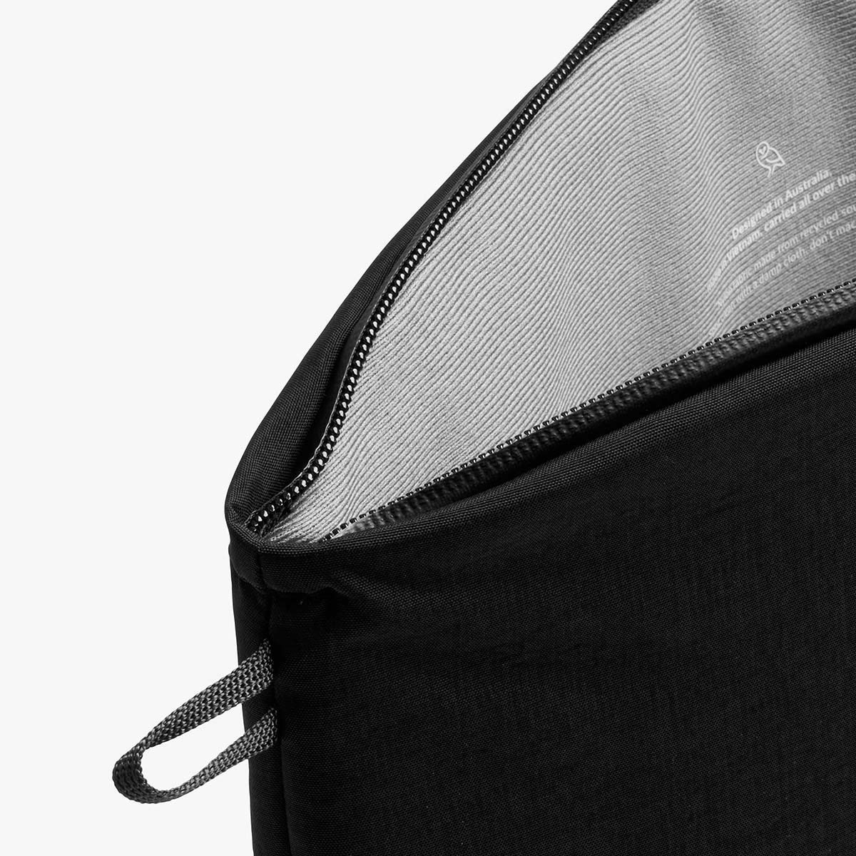 Borsa nera con cerniera aperta e linguetta in tessuto.