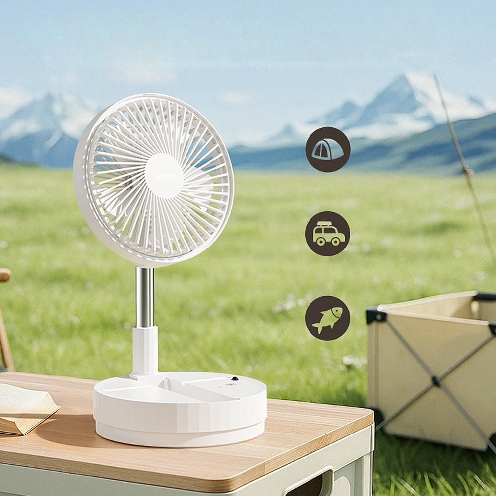 Un ventilador portátil blanco sobre una mesa al aire libre con montañas al fondo.
