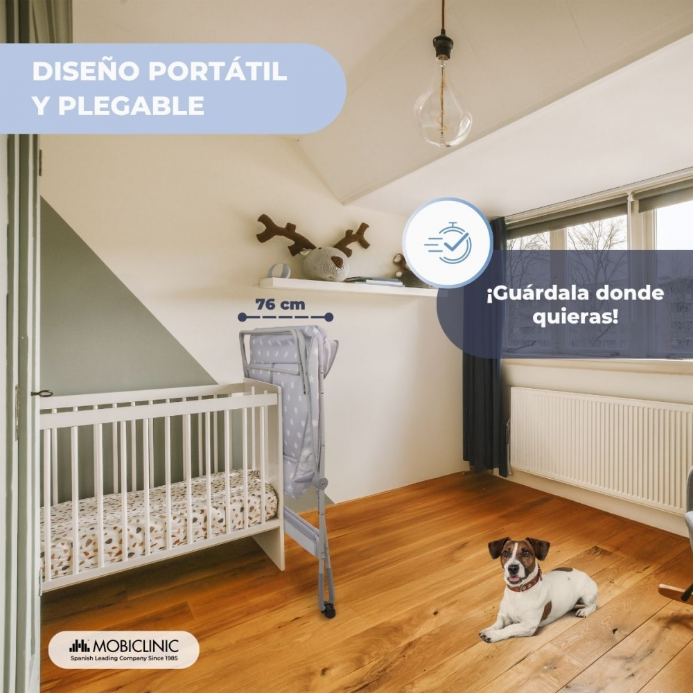 Una cuna, un cambiador plegable y un perro en una habitación.