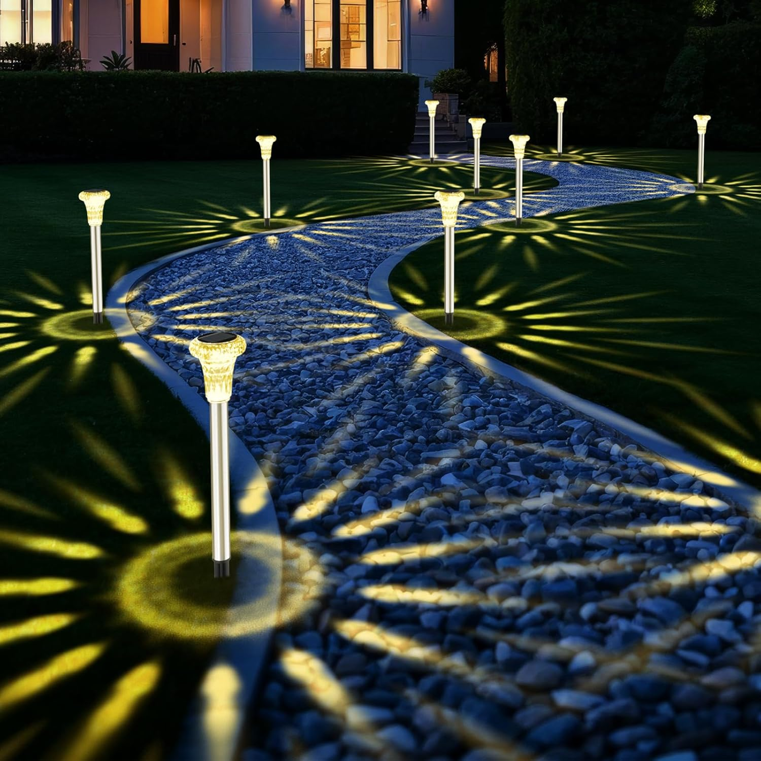 Solarleuchten beleuchten einen Kiesweg und Rasen mit gelben Lichtmustern.