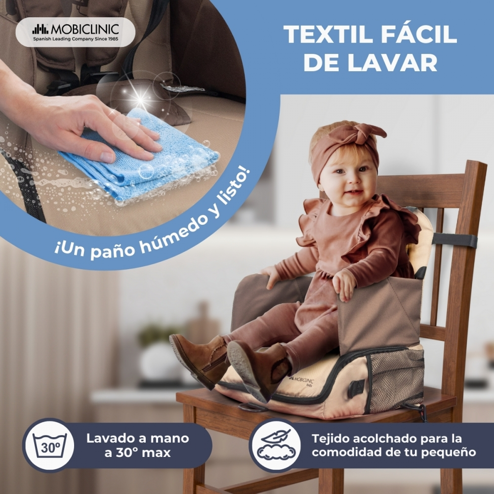 Bebé en trona. Mano limpiando con paño. Tejido fácil de lavar.