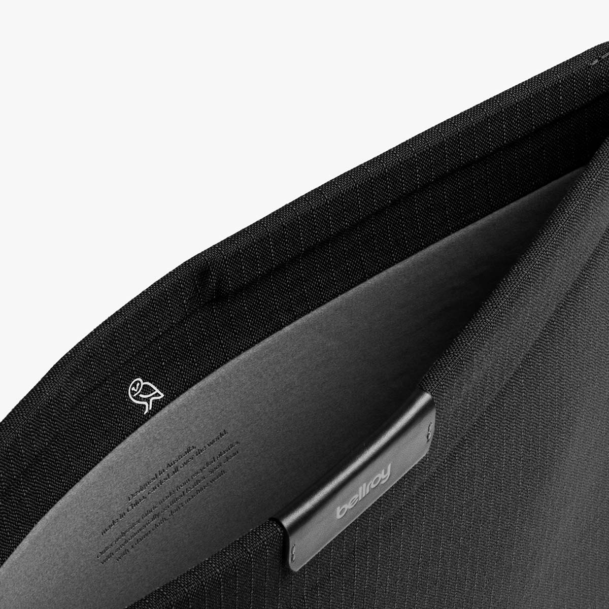 Borsa nera con logo Bellroy all'interno e piccolo logo gufo.