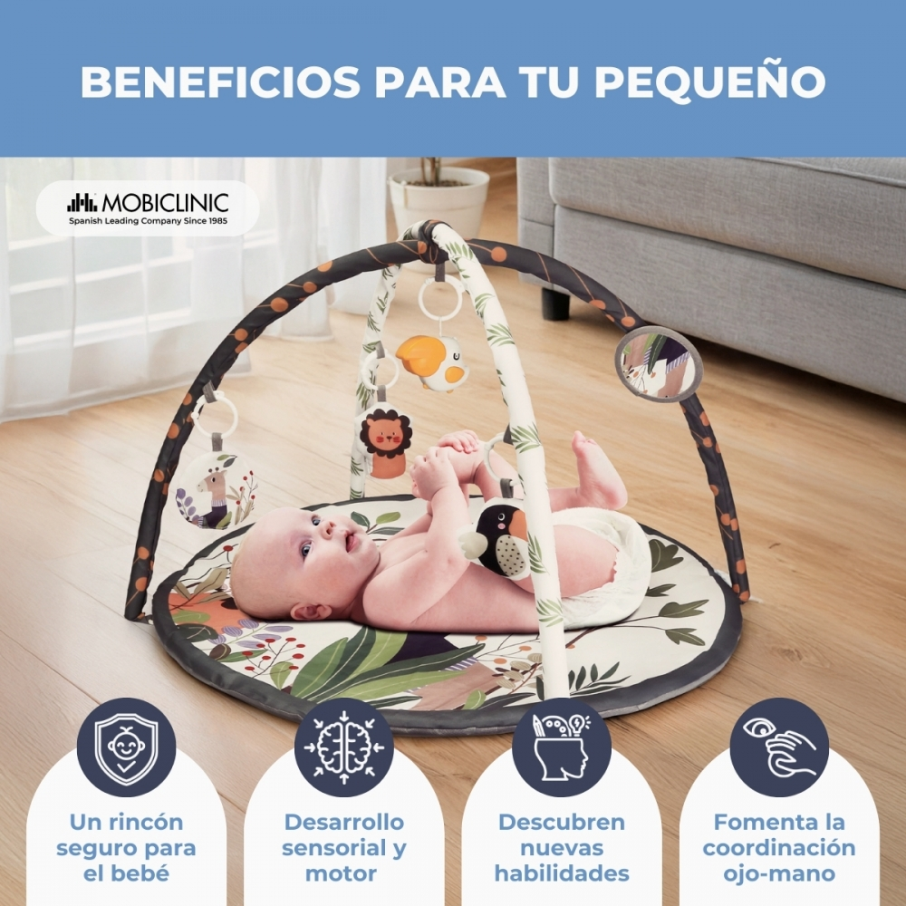 Bebé en alfombra de juegos con juguetes colgantes. Cuatro iconos abajo.