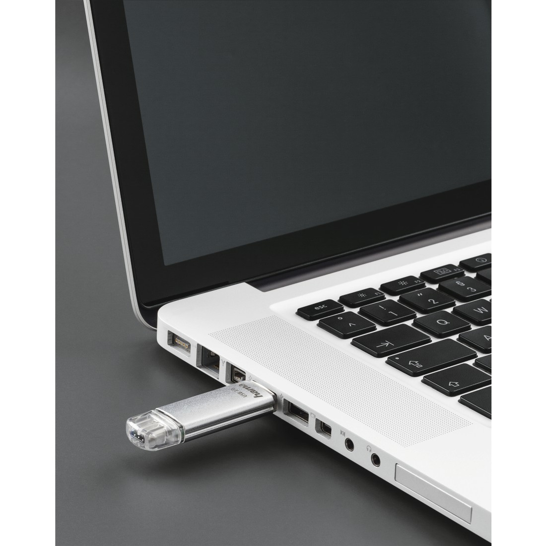 Une clé USB est branchée sur un ordinateur portable ouvert.