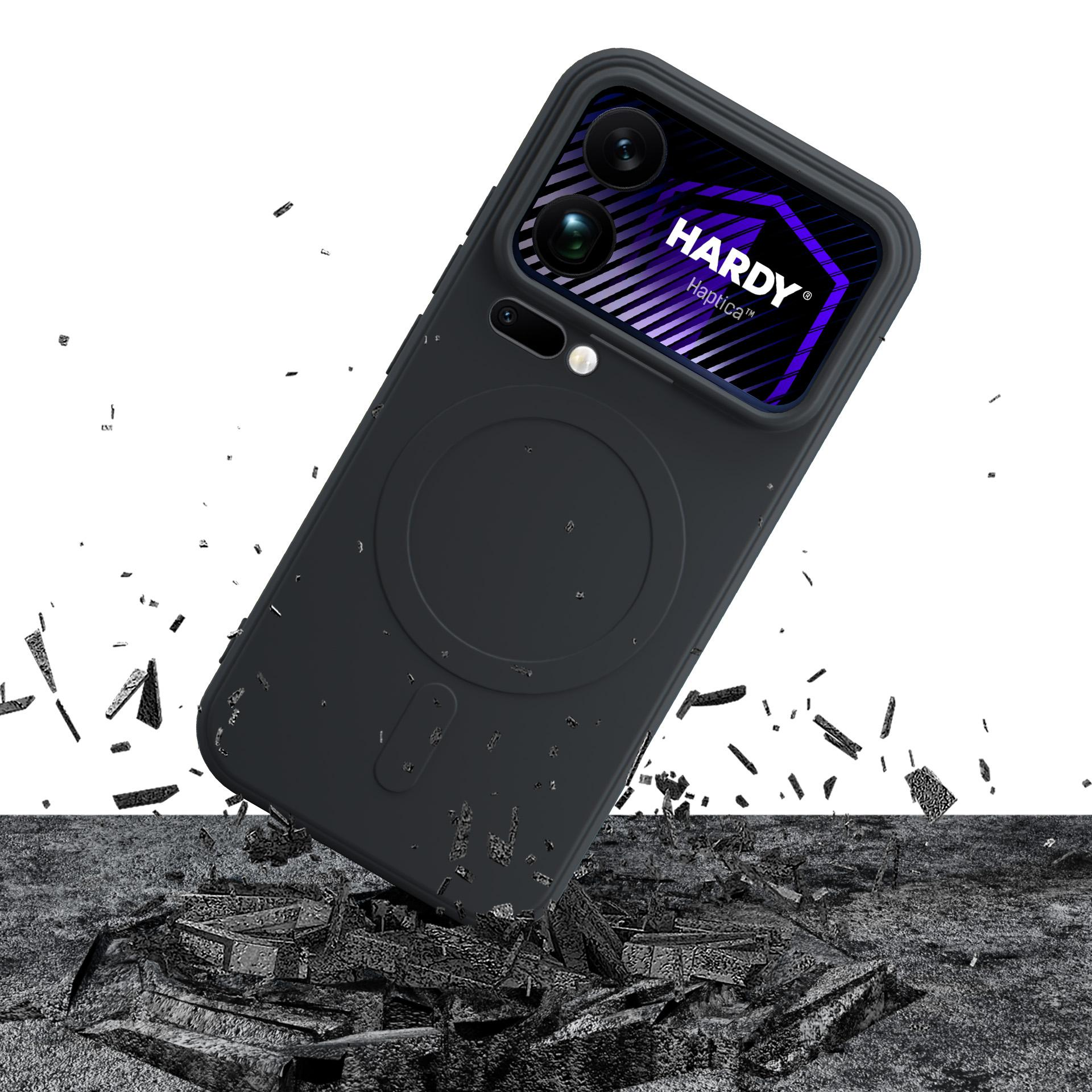 Czarny telefon z napisem Hardy Haptica spada na gruzy.