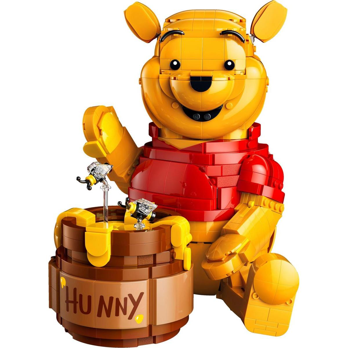 Sarı Lego Koca Ayı, küçük arıların olduğu bir bal kavanozunun yanında oturuyor.