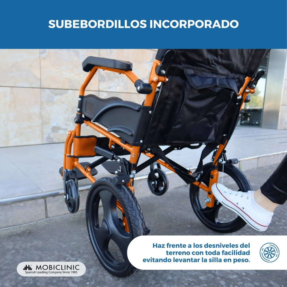 Una silla de ruedas naranja con subebordillos integrados se encuentra en una calle.