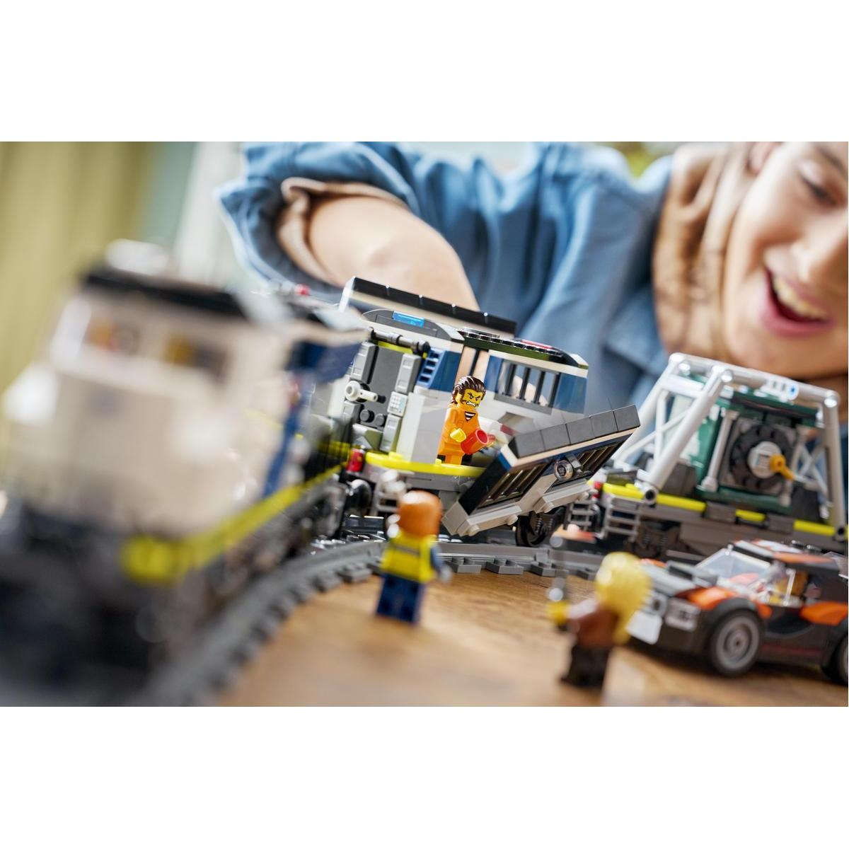 Tren Lego con figuras y coche en mesa de madera, un niño juega.