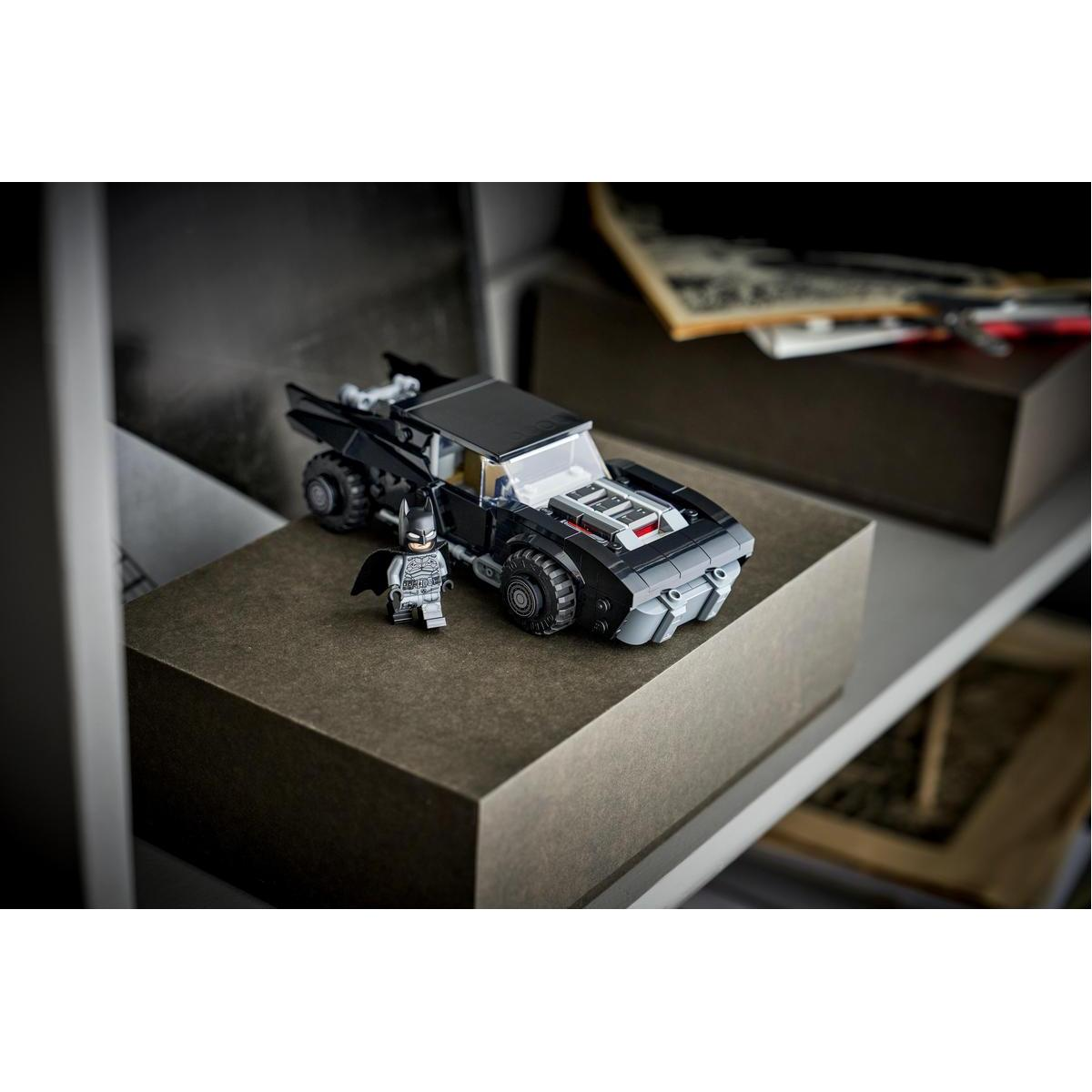 Figurka Lego Batman obok czarnego Lego Batmobilu na pudełku.