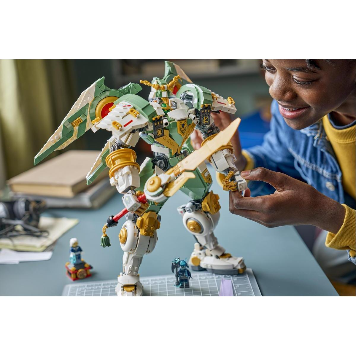 Chłopiec buduje zielonego i białego mecha Lego ze złotymi detalami.