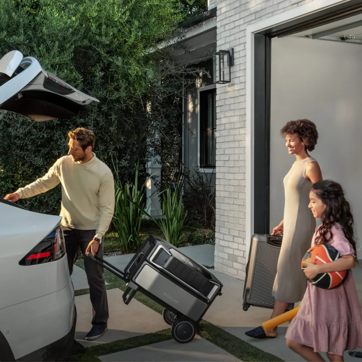 Famiglia carica attrezzatura in auto fuori casa.