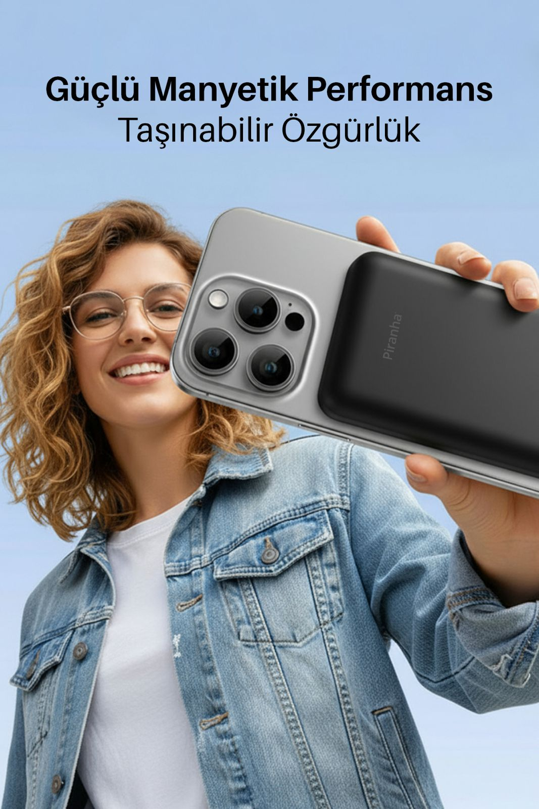 Gözlüklü bir kadın, takılı siyah pil ile bir telefon tutuyor.