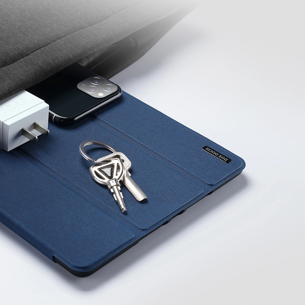 Ein Handy-Ladegerät, Schlüssel und ein Handy liegen auf einer blauen Hülle.