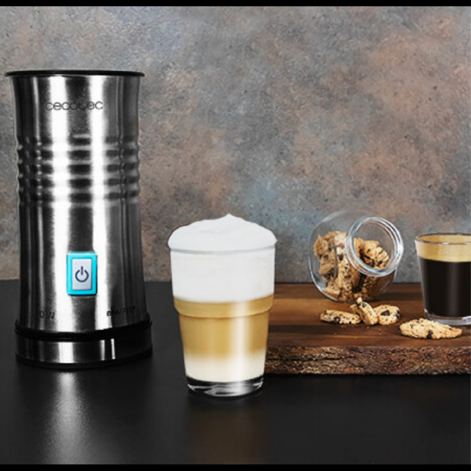 Spieniacz do mleka, latte macchiato, espresso i ciasteczka na stole.