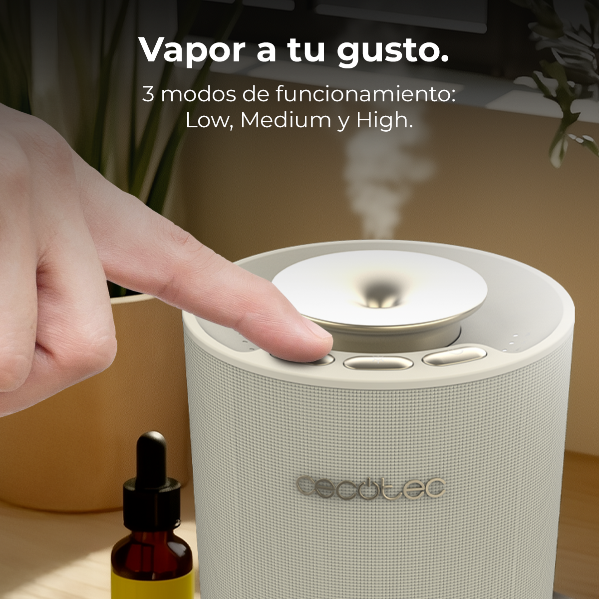 Una mano preme un pulsante su un diffusore beige che emette vapore.