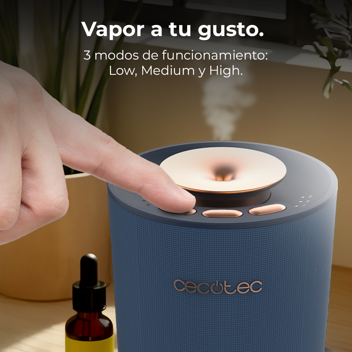 Una mano preme un pulsante su un diffusore blu con accenti in rame.