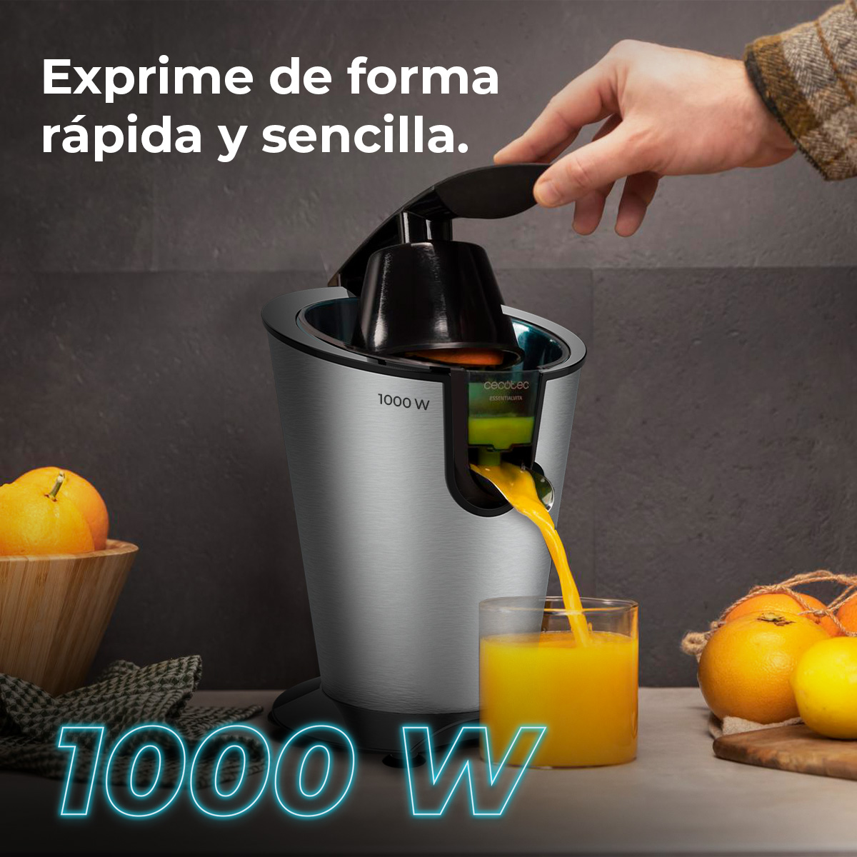 Un exprimidor plateado extrae zumo de naranja en un vaso. Hay naranjas cerca.