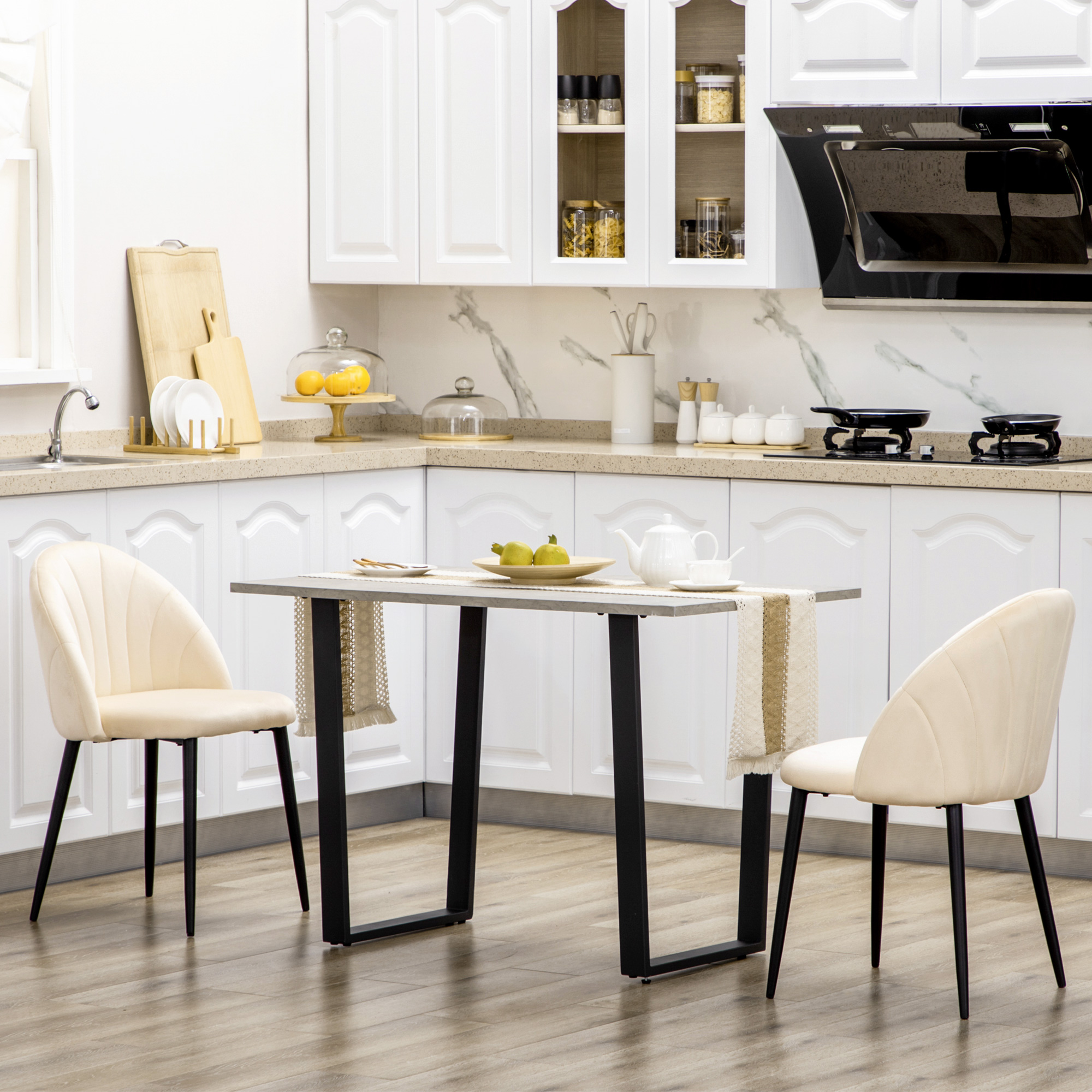 Una cucina moderna con mobili bianchi, un tavolino e due sedie.