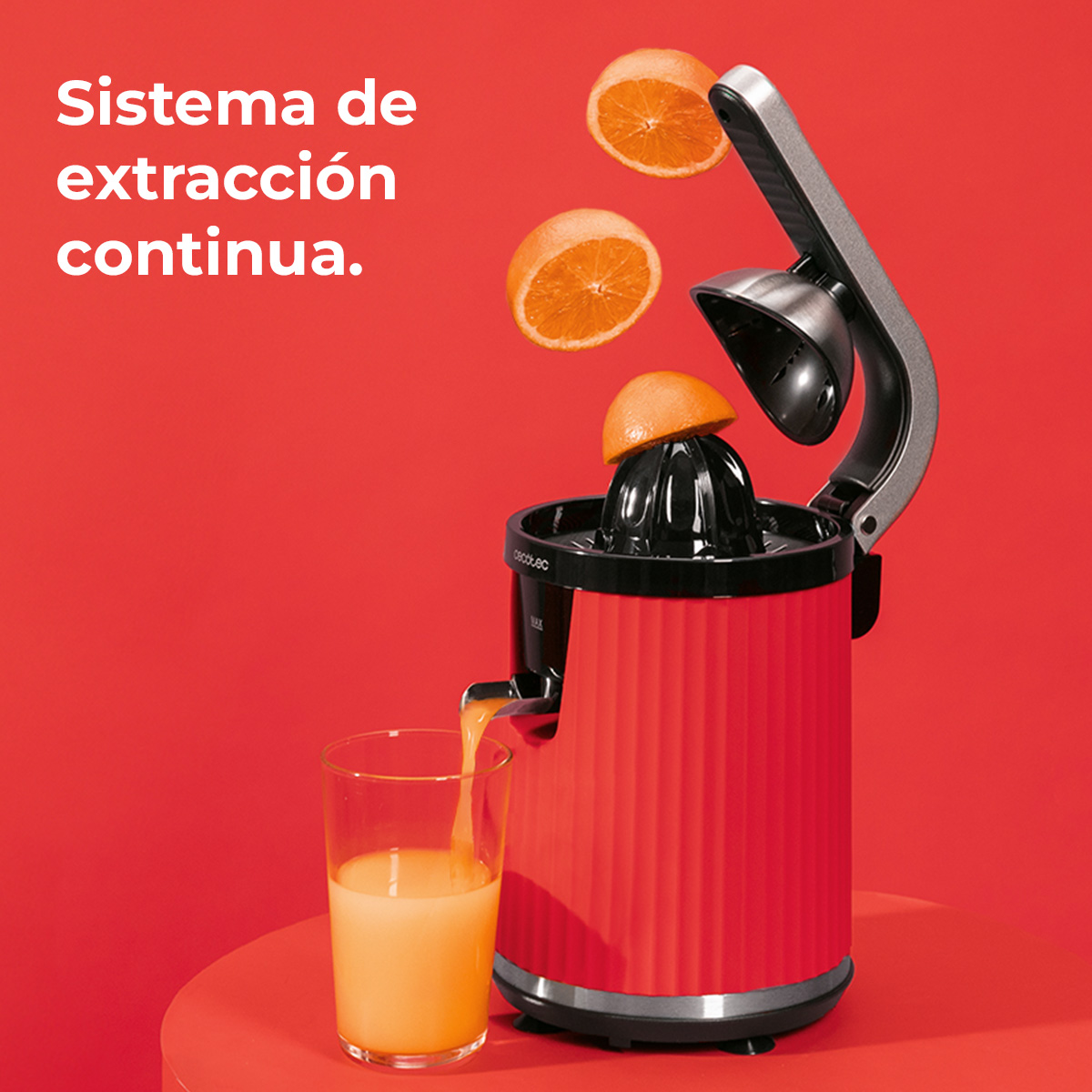 Un spremiagrumi rosso estrae arance. Il succo scorre in un bicchiere.