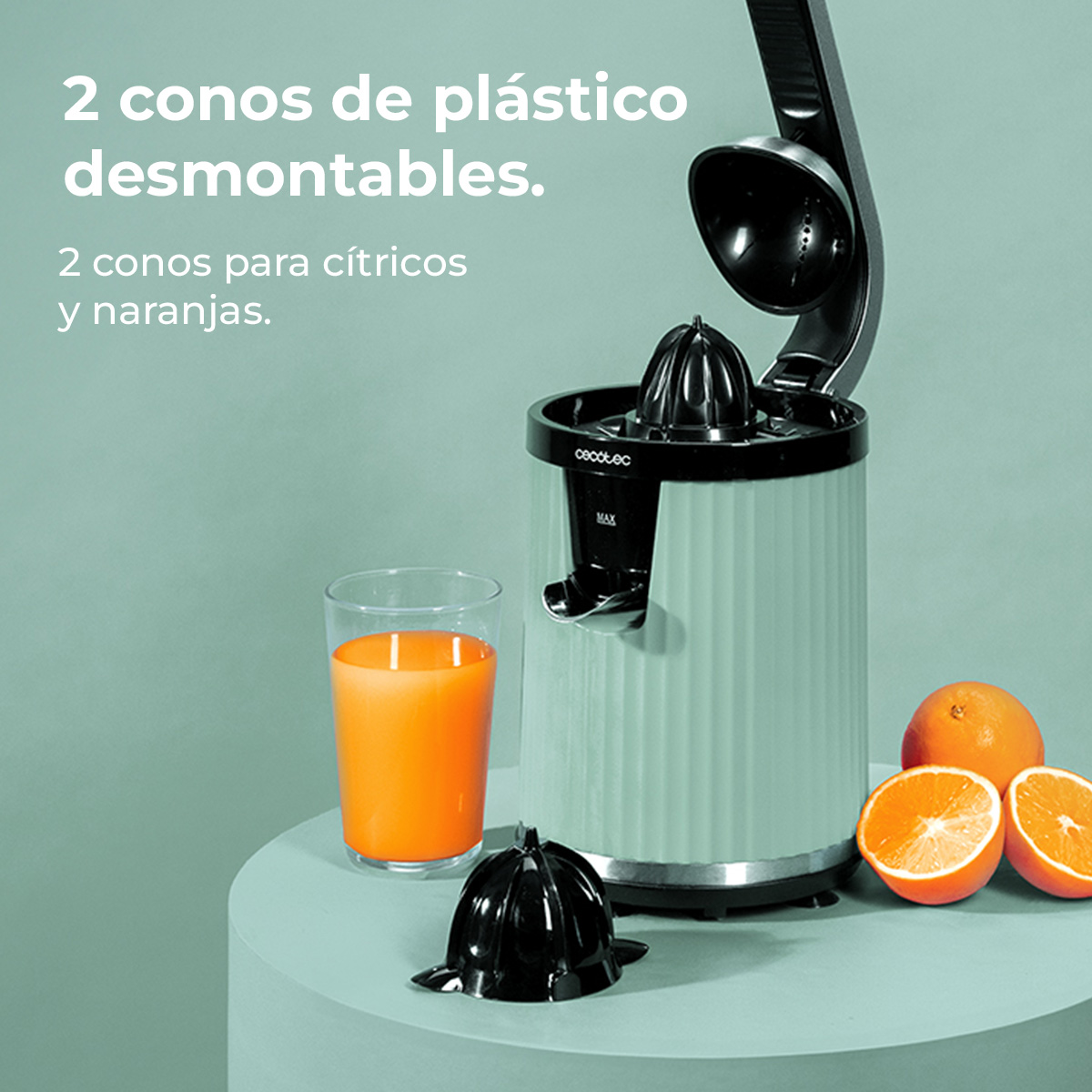 Un exprimidor con un vaso de zumo de naranja, naranjas y conos de repuesto.