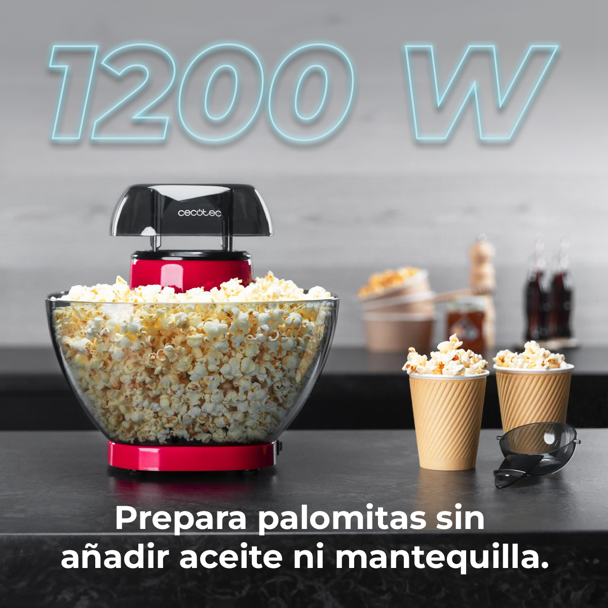 Macchina per popcorn rossa 1200W piena di popcorn. Due bicchieri di popcorn accanto.