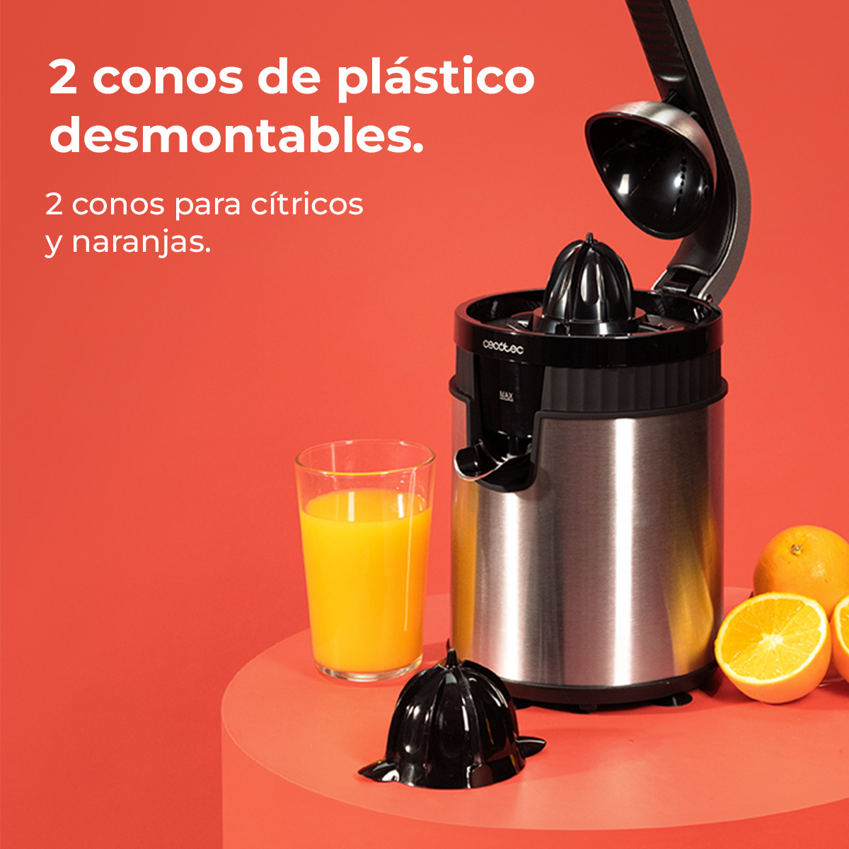 Een roestvrijstalen elektrische citruspers met een glas sinaasappelsap en sinaasappels.